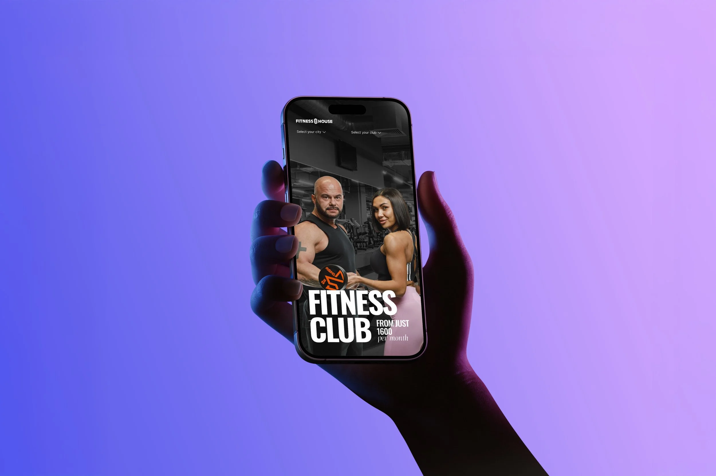 A hand holding a smartphone displaying a fitness club advertisement with a muscular man and woman inside a gym.