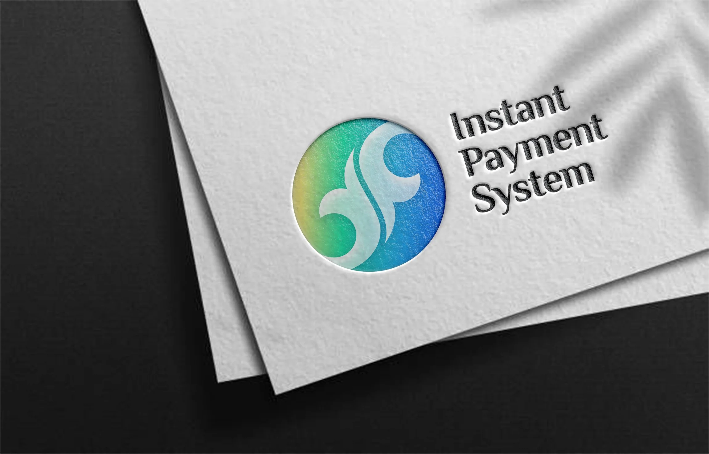 Close-up of an embossed paper with a colorful logo and the words 'Instant Payment System' printed on it.