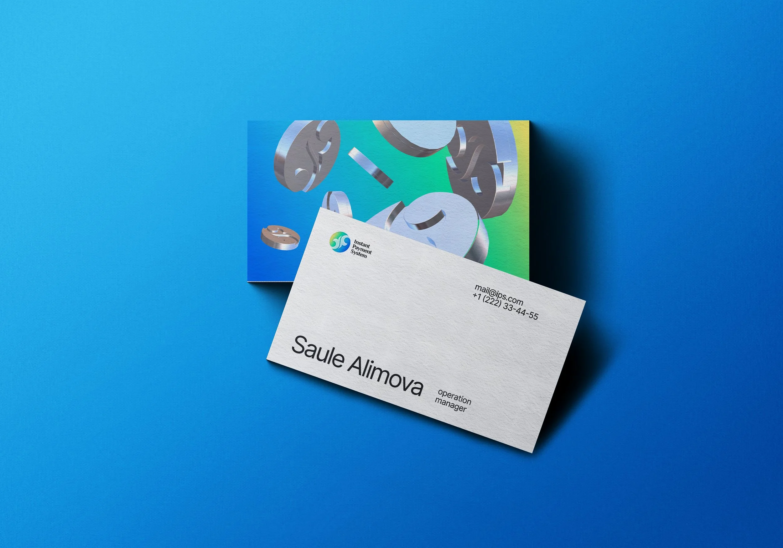 Business cards and an artwork featuring metallic gears on a colorful background, placed on a blue surface.