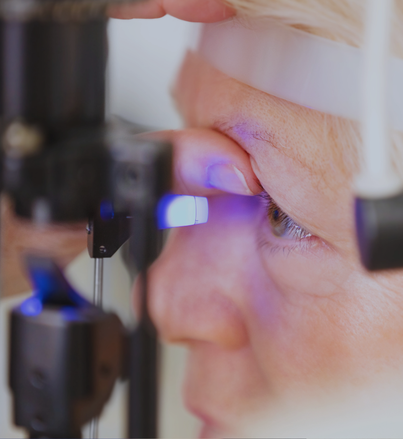 Close-up of a person undergoing an eye examination using a slit lamp microscope.
