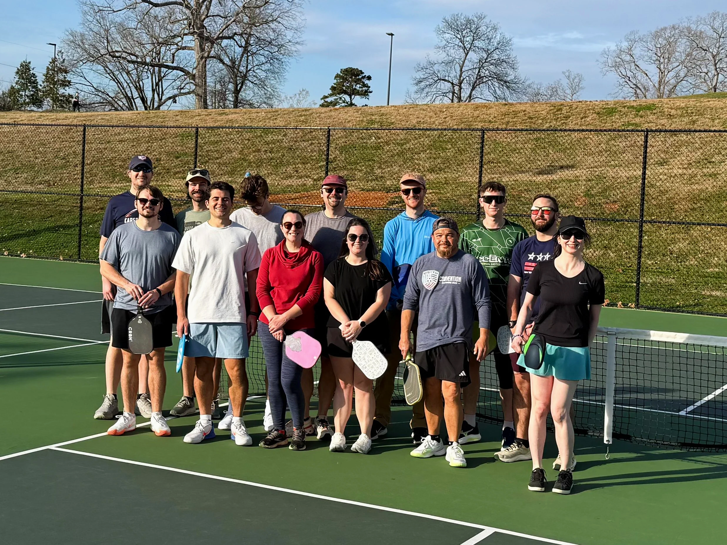 People doing warm-up exercises outdoors on a sunny day