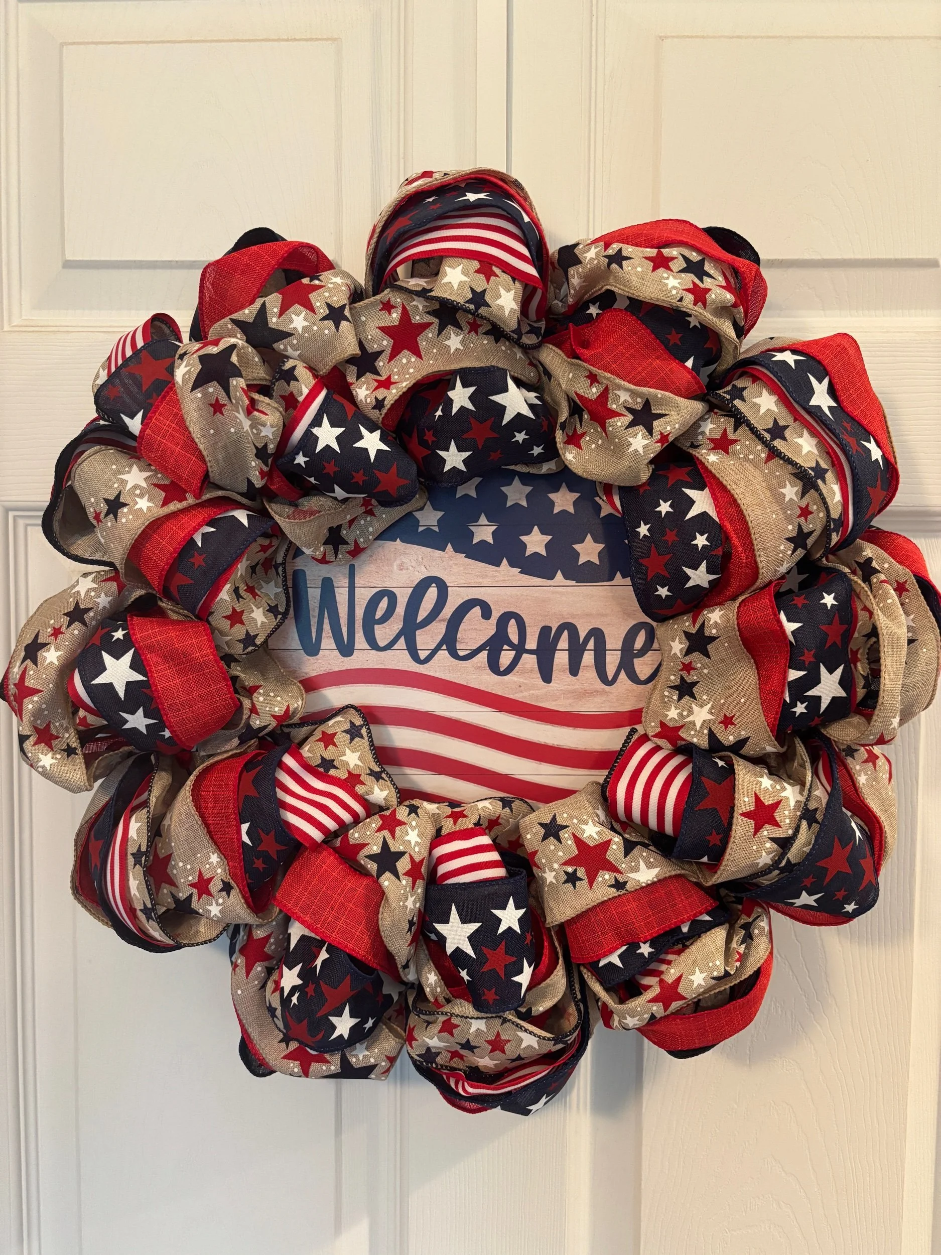 Red and blue ribbon with burlap equipped with stars and stipes. A welcome sign with stars and stipes in the center