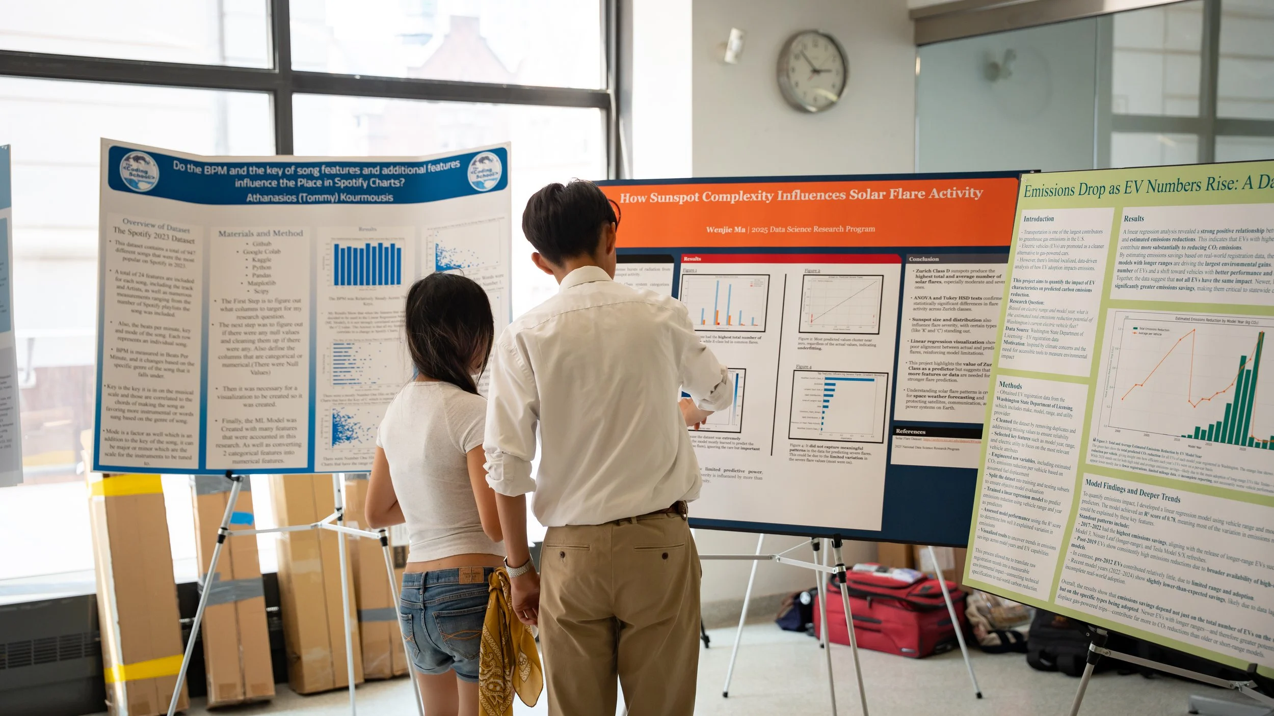 Two students reading a research poster presentation at a conference or academic event.