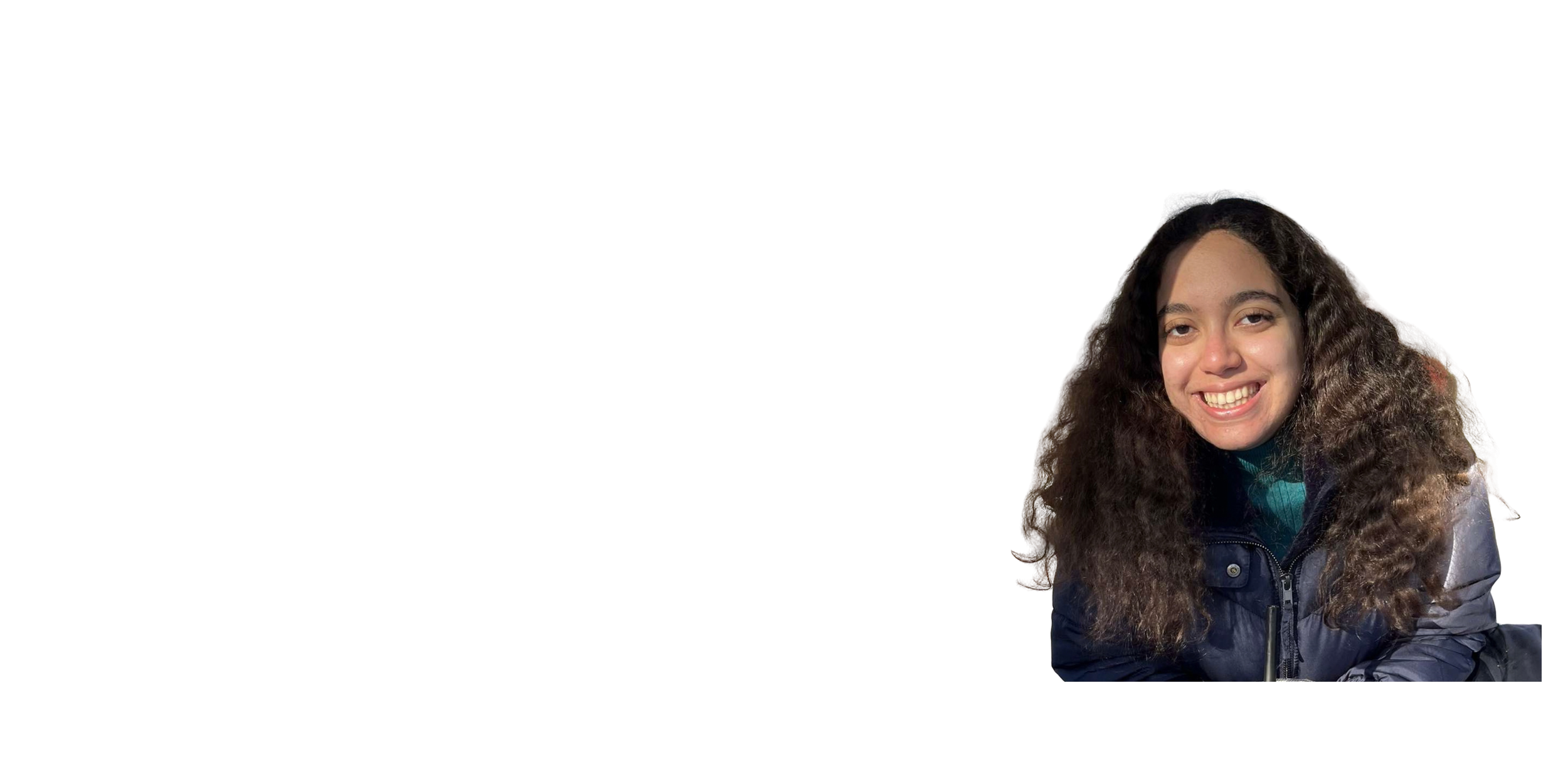 A young woman with curly hair smiling, wearing a dark jacket and sitting against a white background.