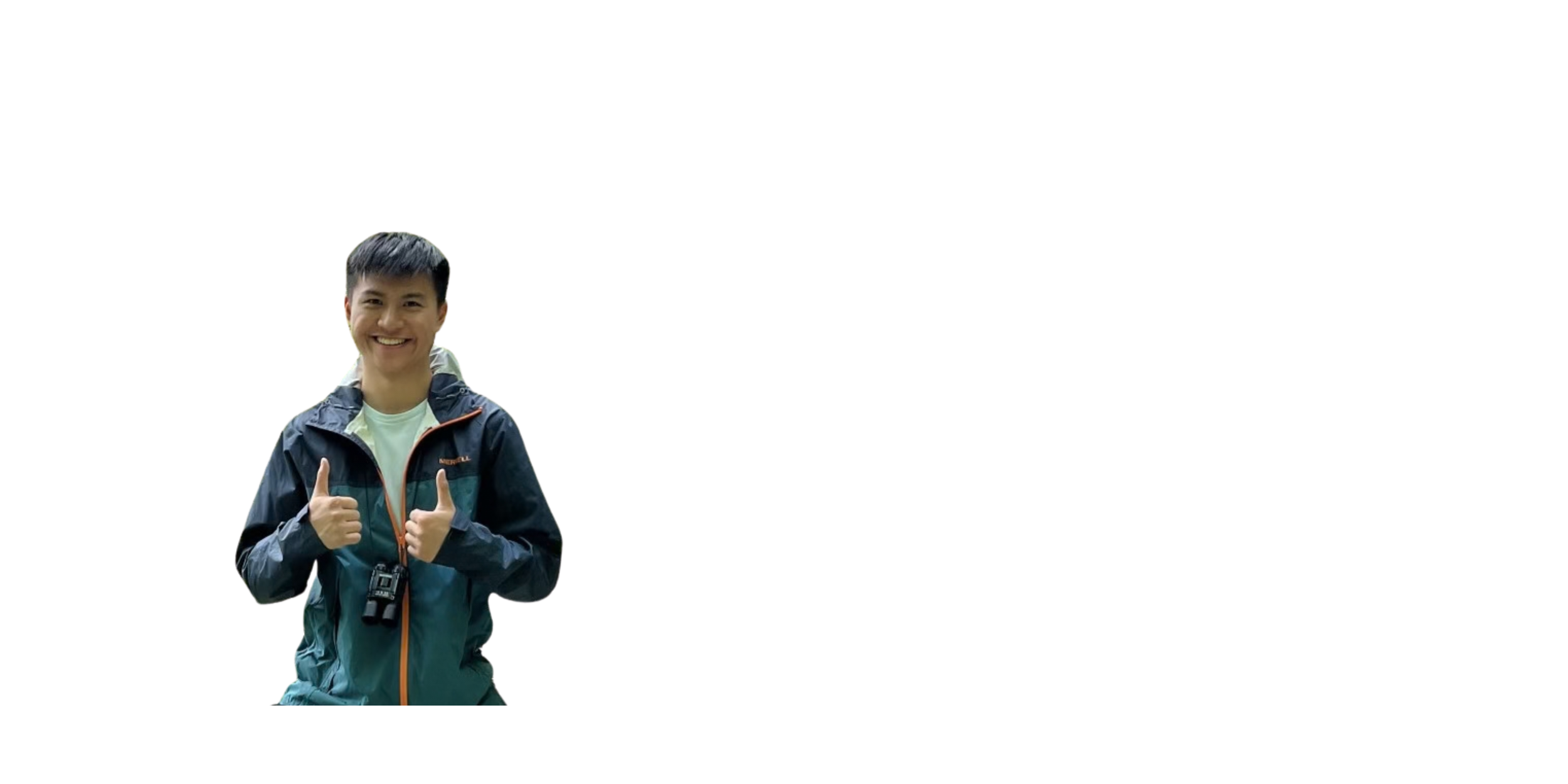 A young man smiling and giving two thumbs up while wearing outdoor gear and a camera around his neck.