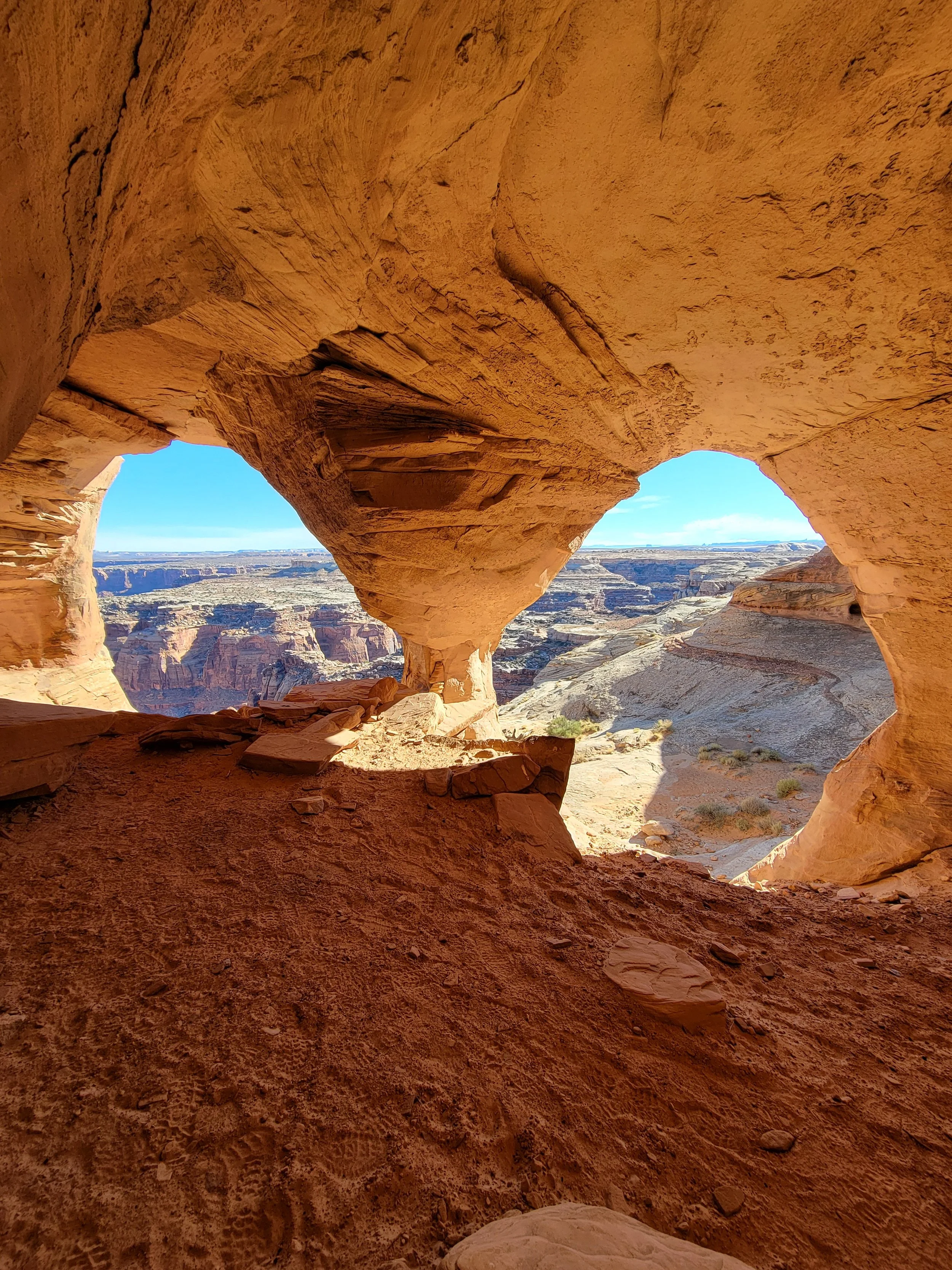 View of a desert canyon landscape through two natural rock arches