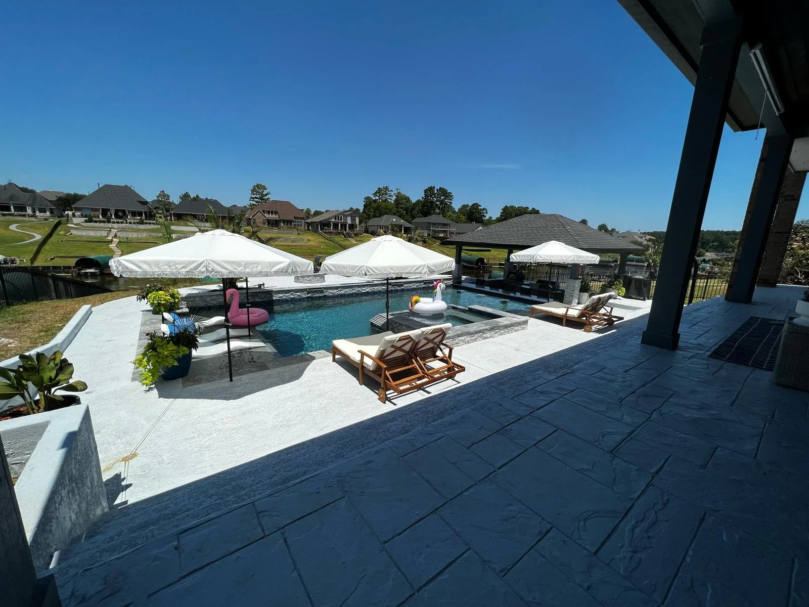 Pool deck design - complete with a sun deck, hot tub, pool waterfall, and drop down projector on porch!