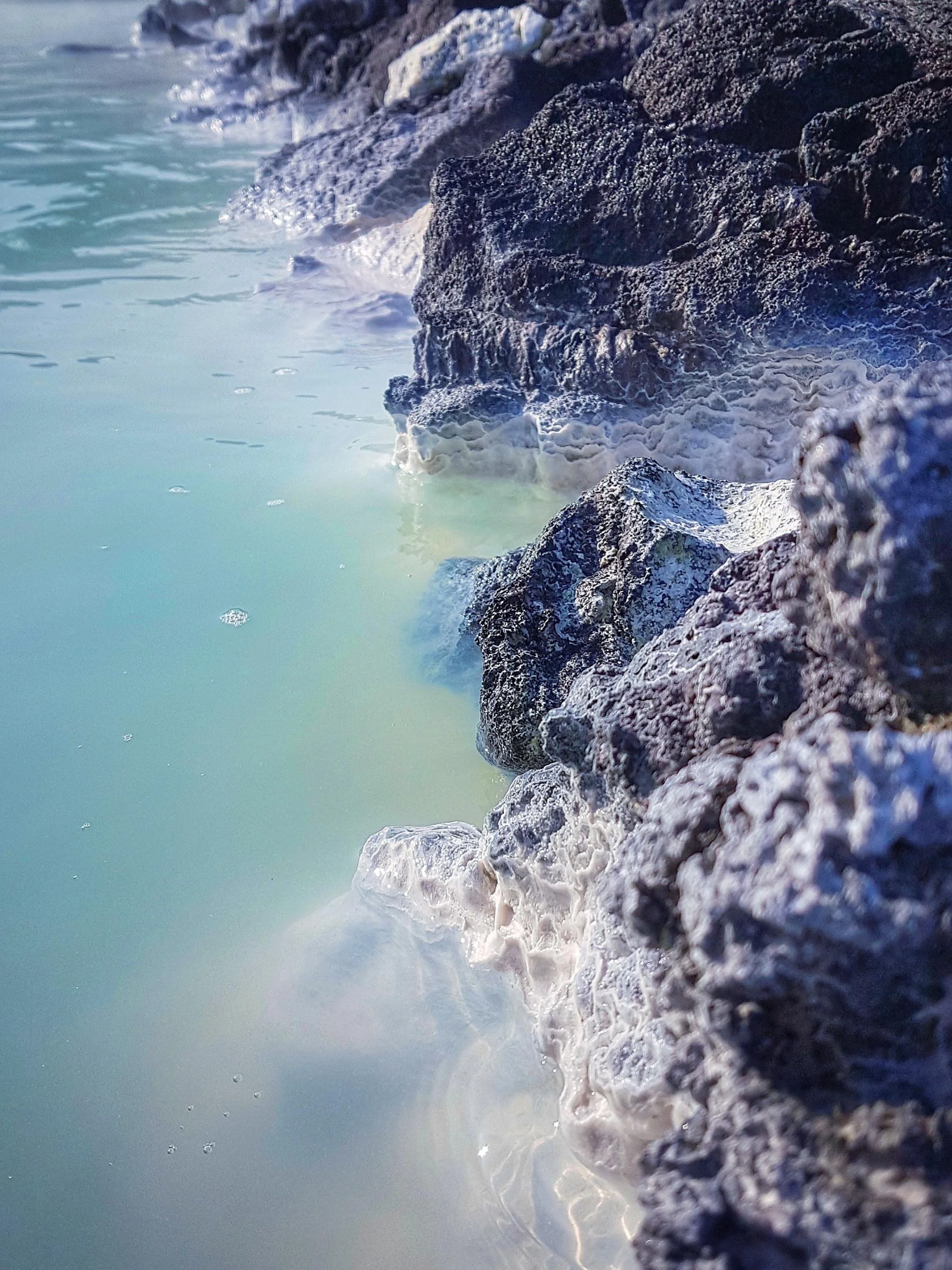 Sea rocks with milky blue water crashing against them