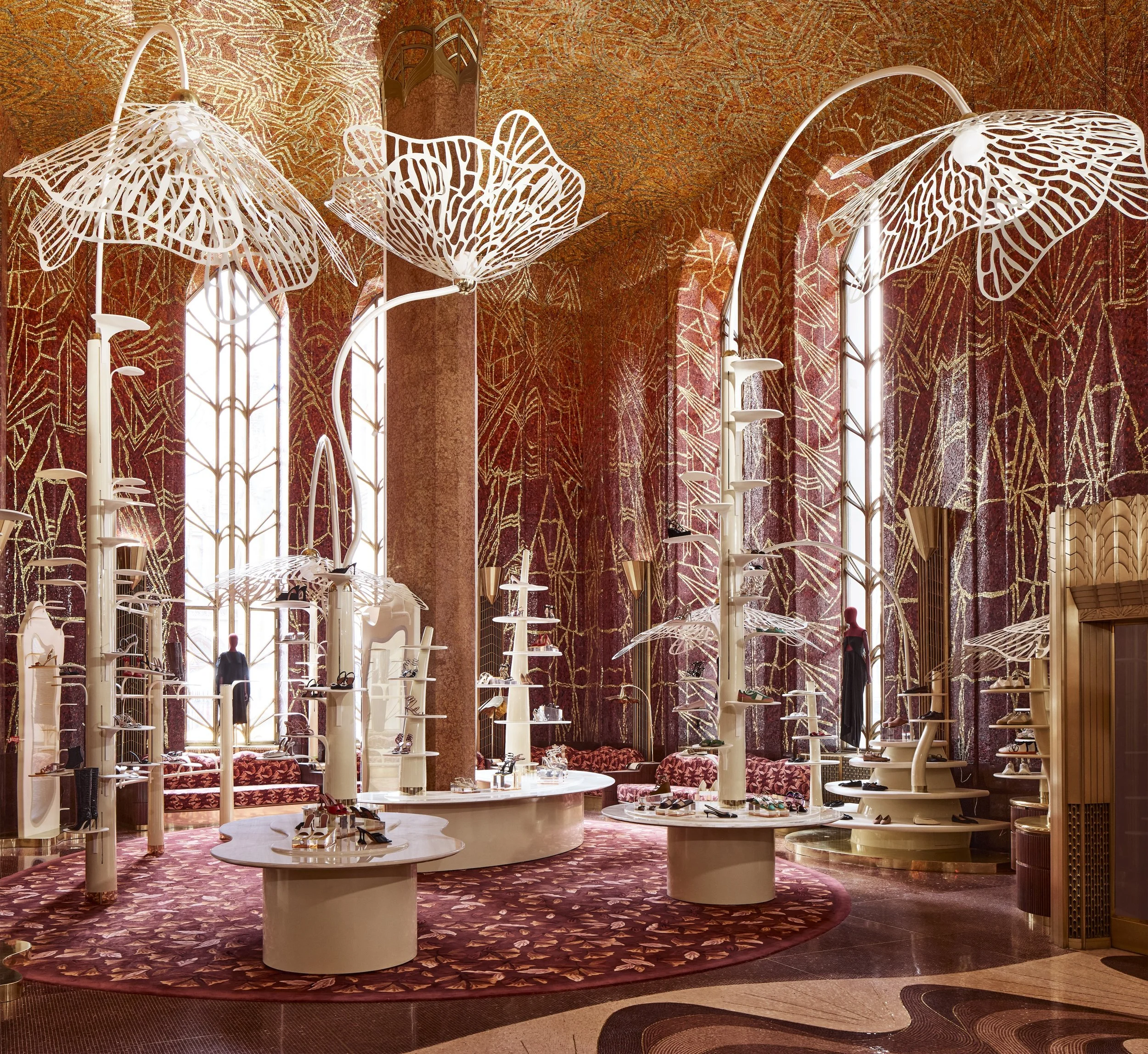 A whimsical shoe store designed like an enchanted forest, featuring towering white sculptural palm trees with intricate leaf canopies overhead.