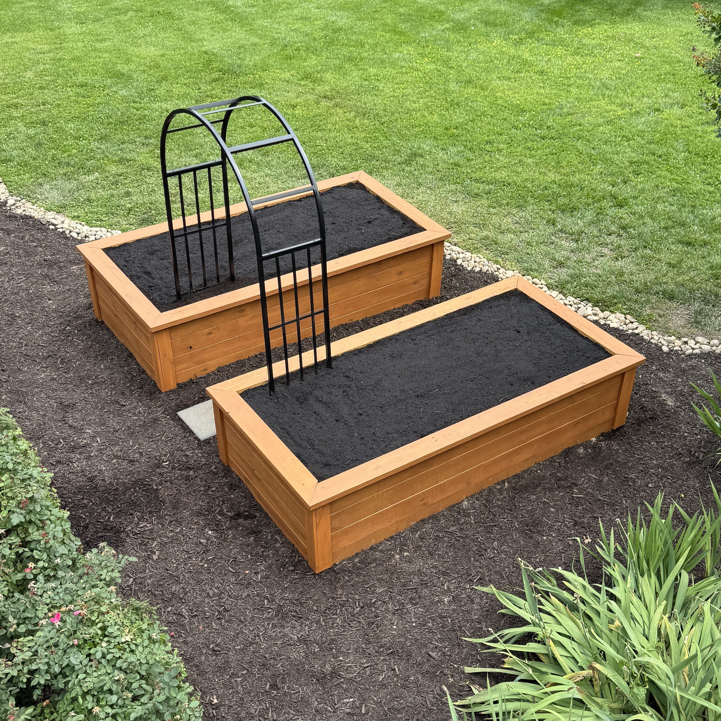 newly installed raised garden beds with iron arch
