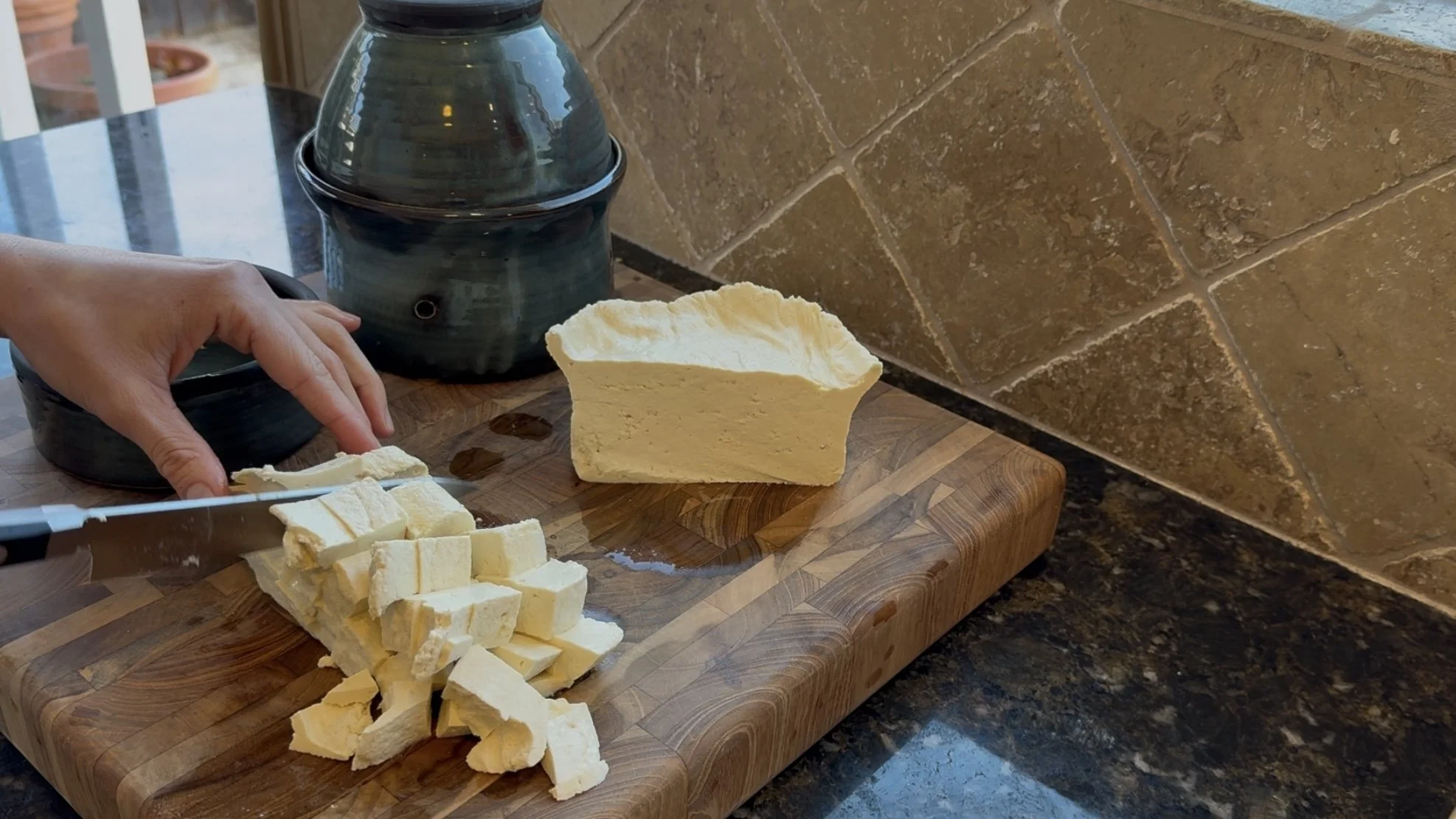 Cutting up homemade tofu, made with the round Thika ceramic tofu mold