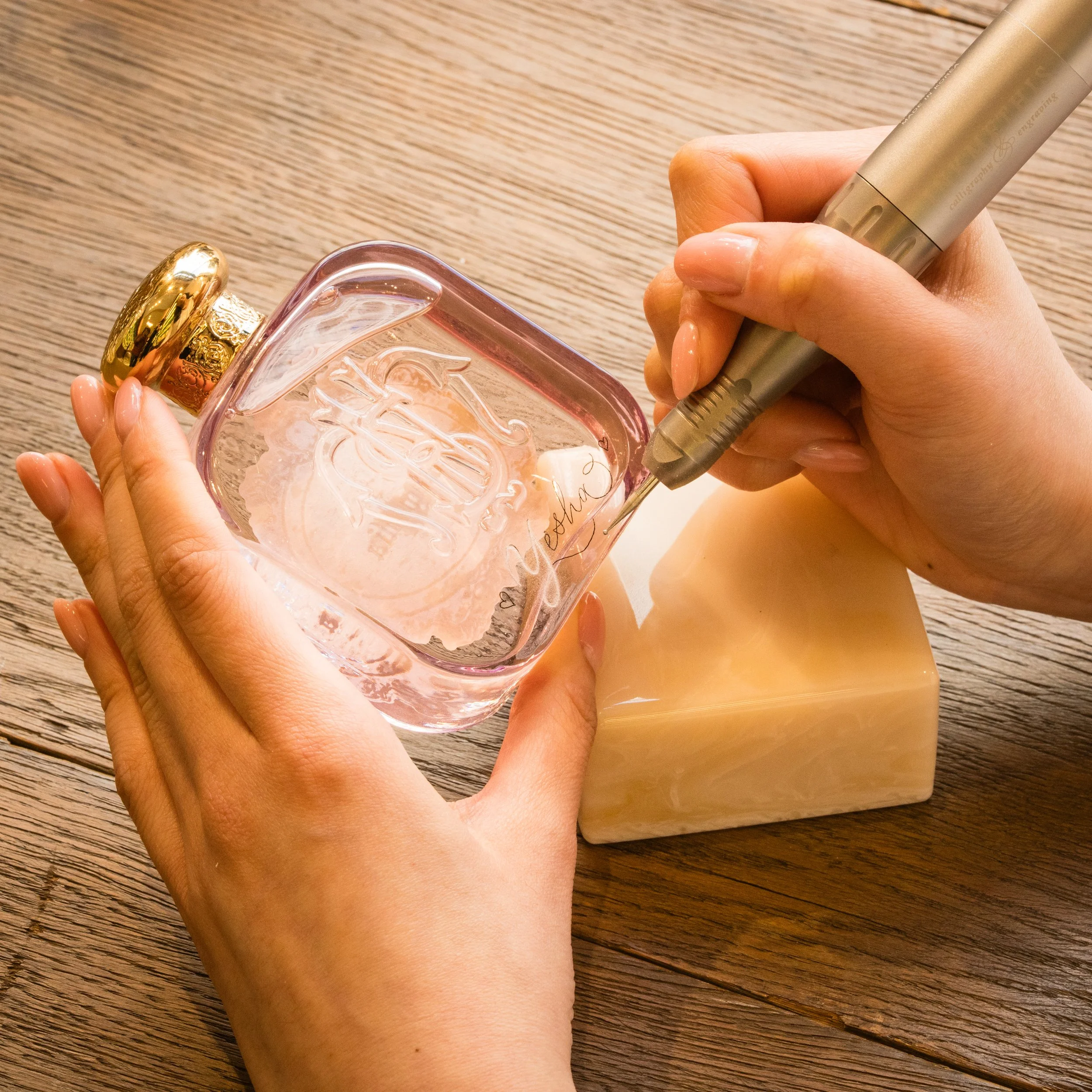 Artist hand engraving luxury fragrance at an in store activation