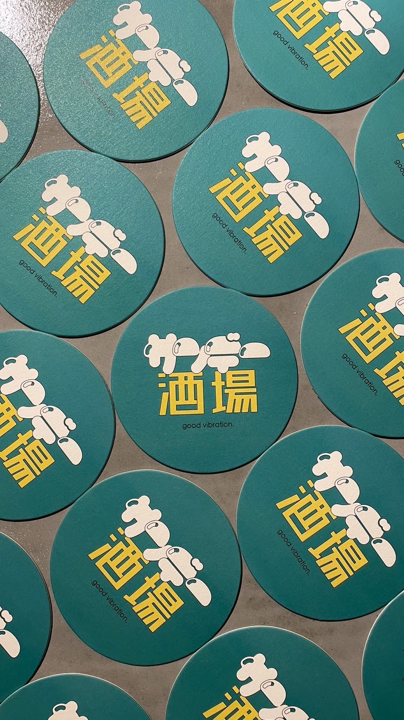 青い丸いステッカーに白いロボットのイラストと黄色い漢字、下に英語で『good vibration』と書かれている。