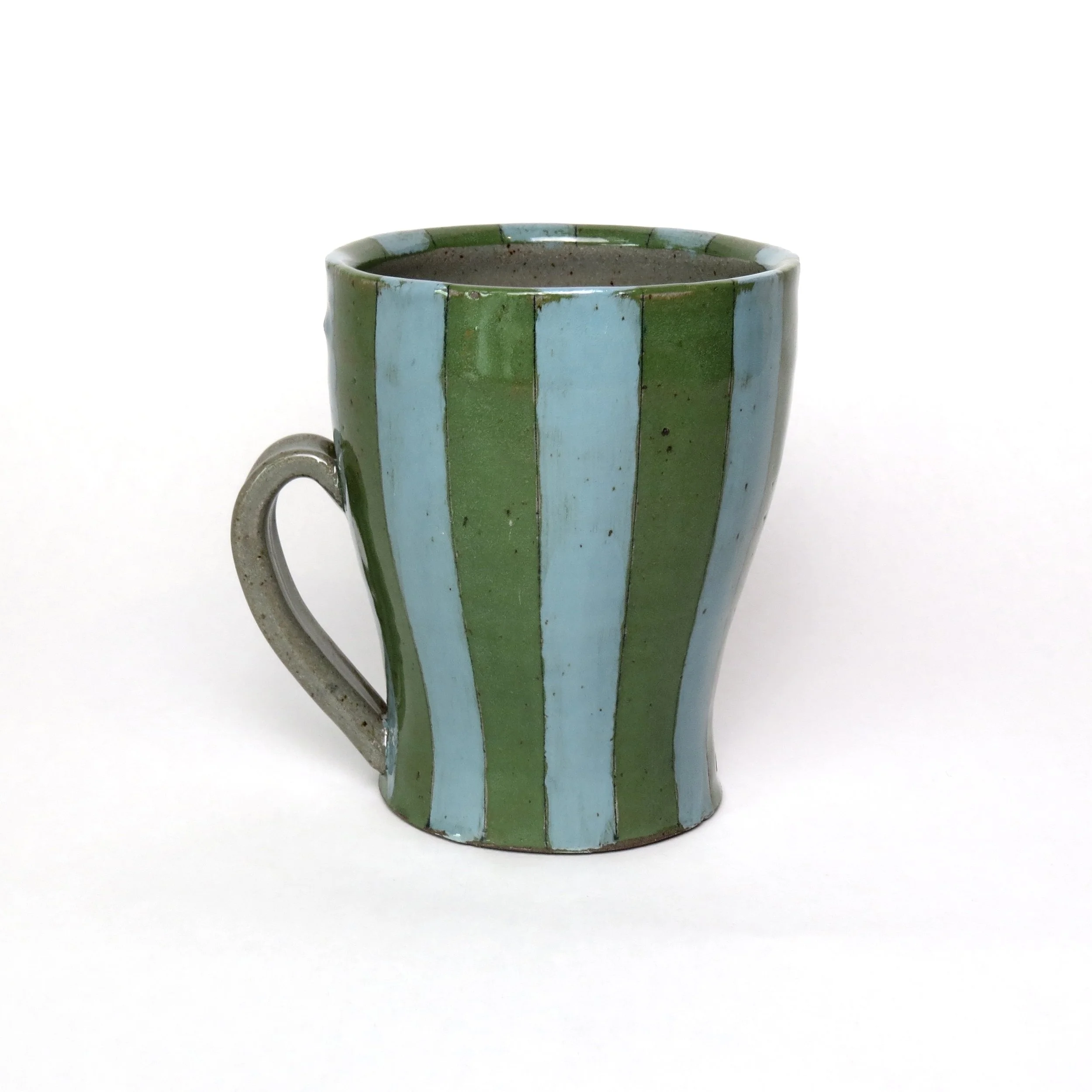 A ceramic mug painted with vertical green and light blue stripes, filled with a dark beverage, placed on a white background.