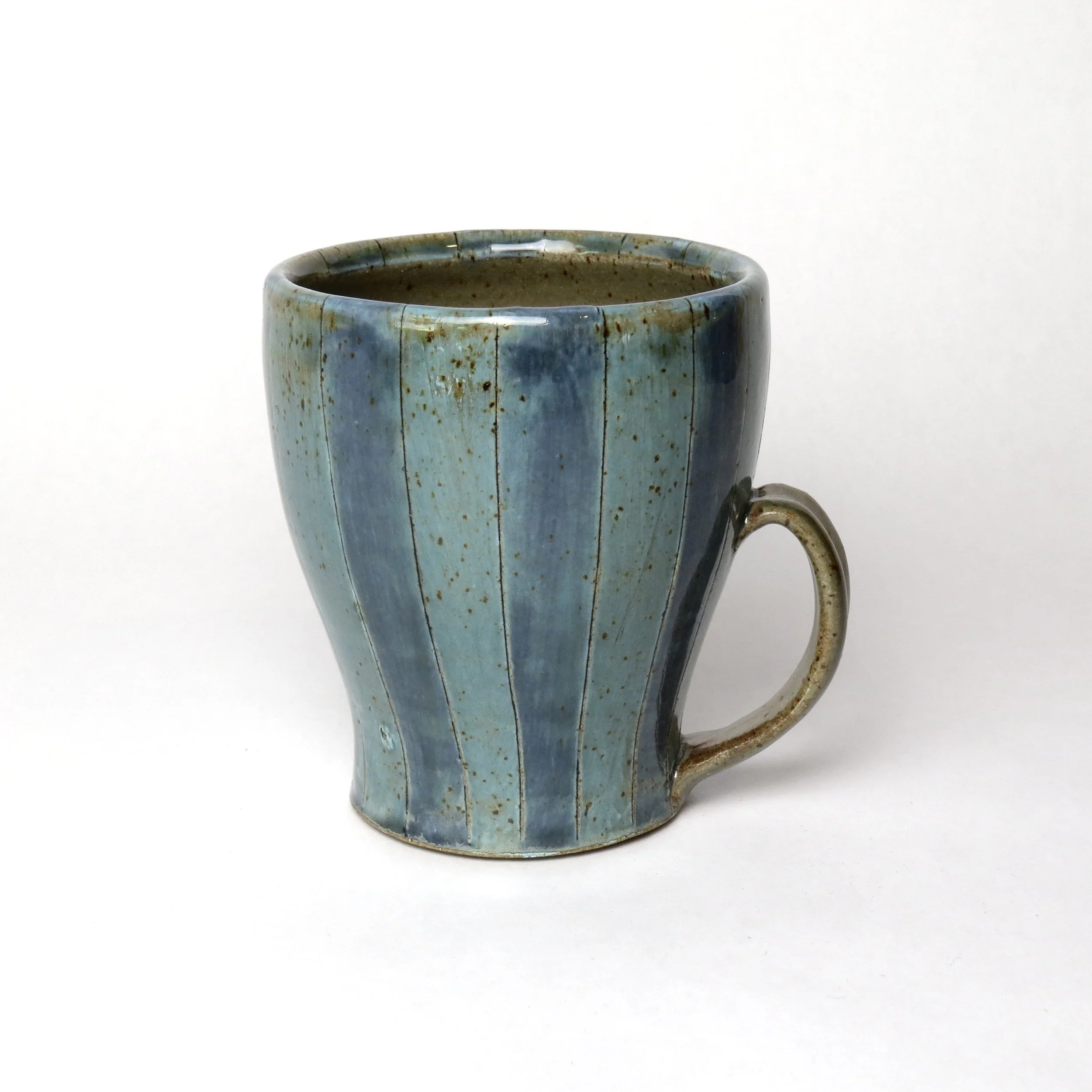 A ceramic mug with a blue glaze and speckled pattern on a white background.