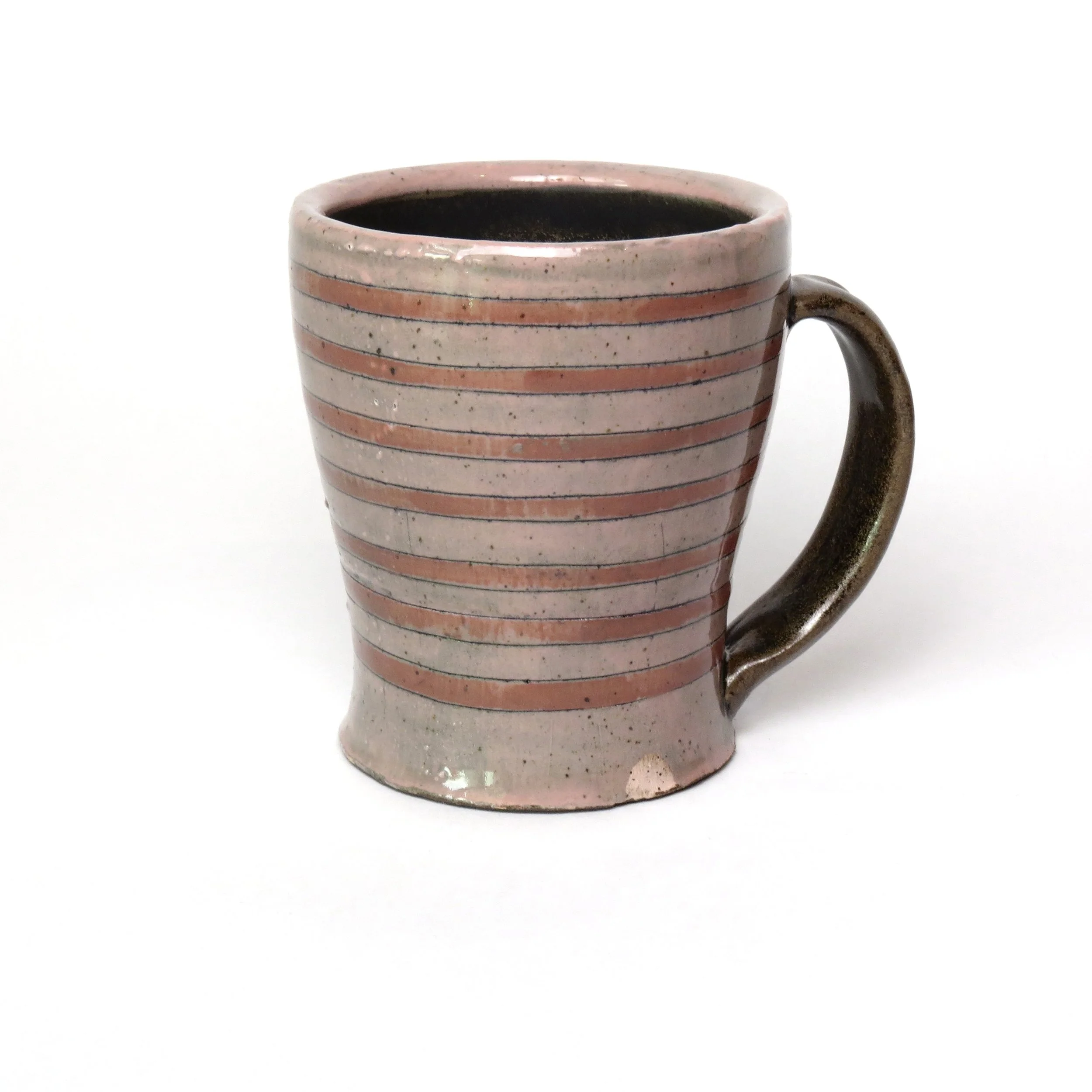 A ceramic mug with horizontal pink and black stripes filled with a dark beverage, positioned against a plain white background.