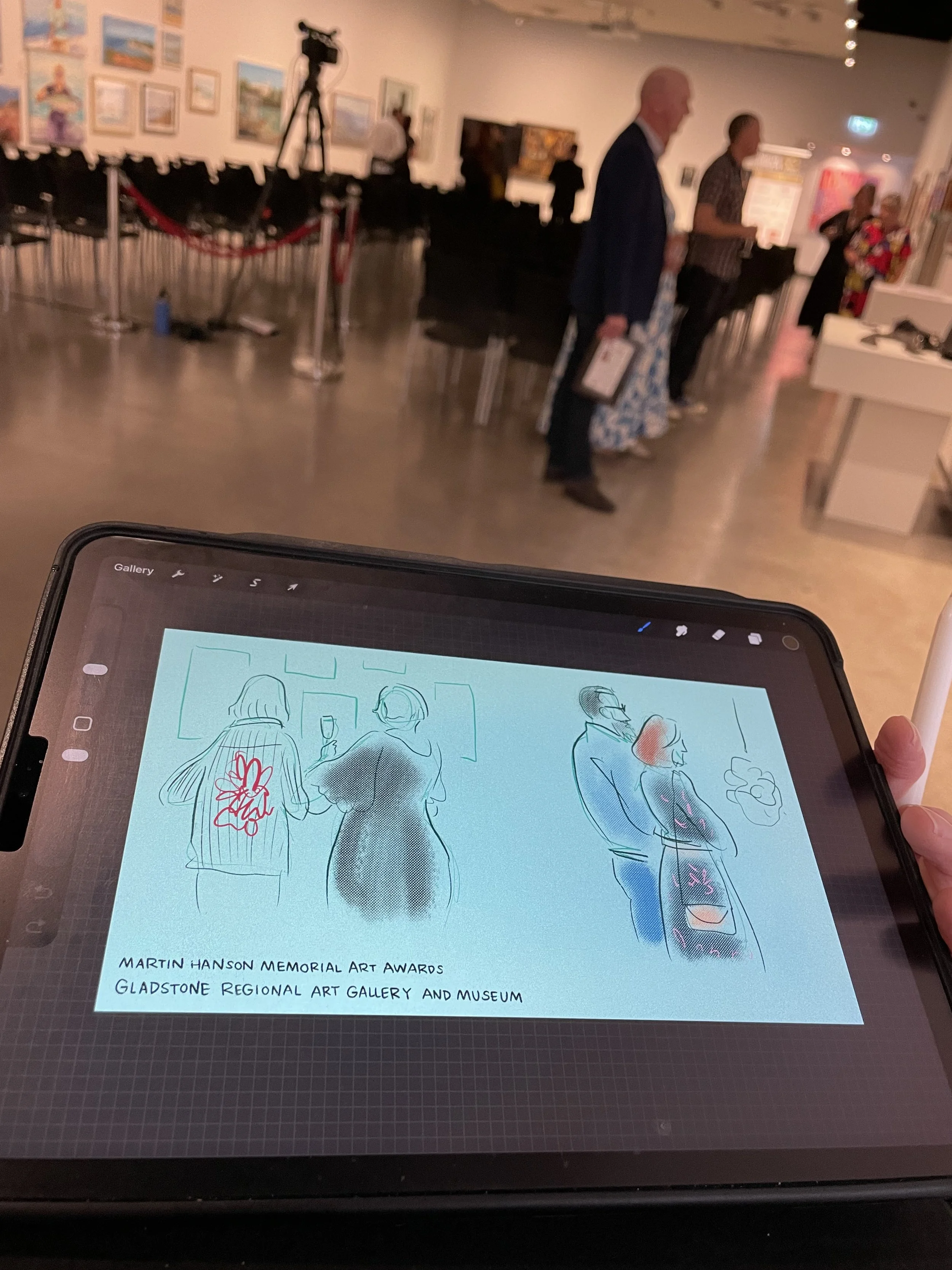 A woman, Megan Herbert, live illustrating a digital portrait and note taking on a tablet at a speakers event