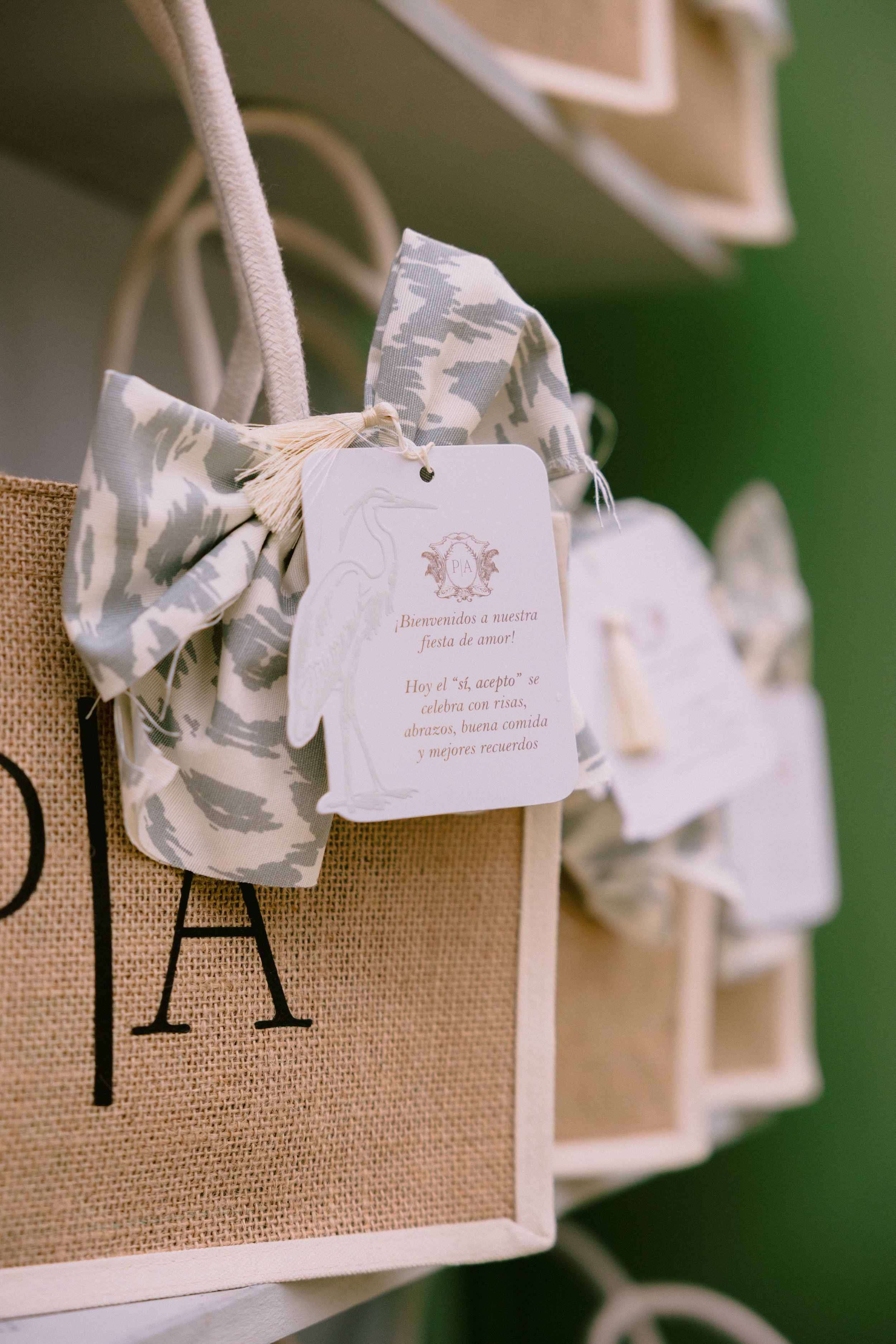 Gift boxes with patterned bows and a card attached, hanging on a display rack.