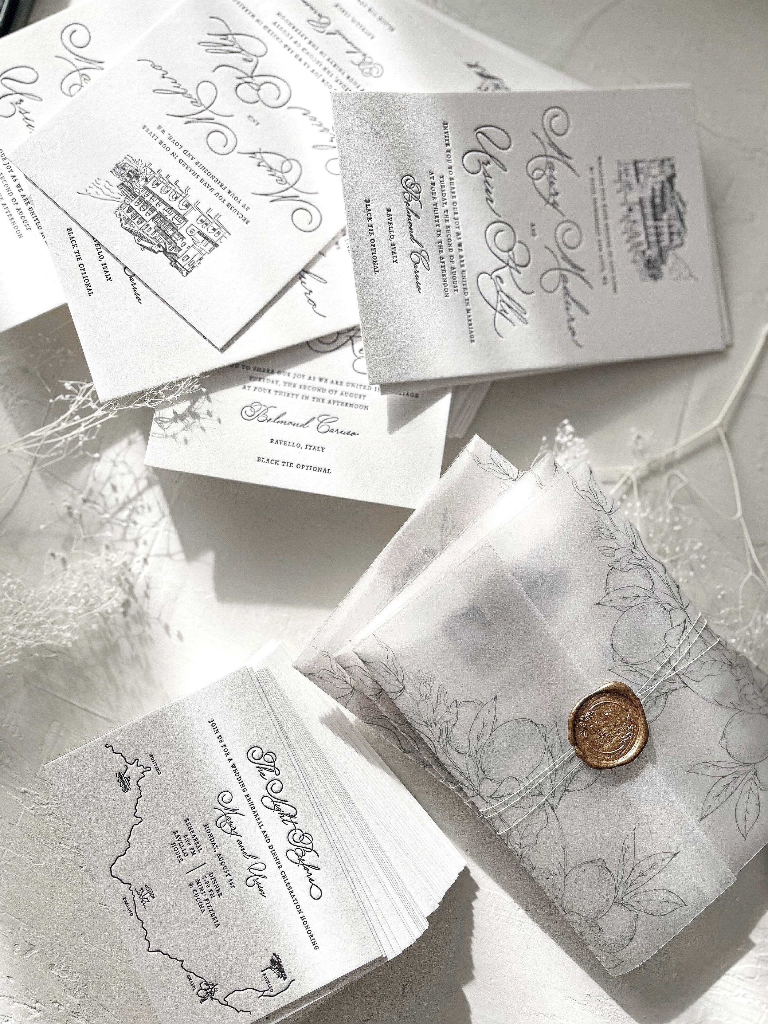 Wedding invitations and stationery with elegant script printed in black letterpress method, on white paper, with a lined design, accompanied by a wax seal and decorative dried flowers. Illustrated Belmond Hotel in Amalfi Coast