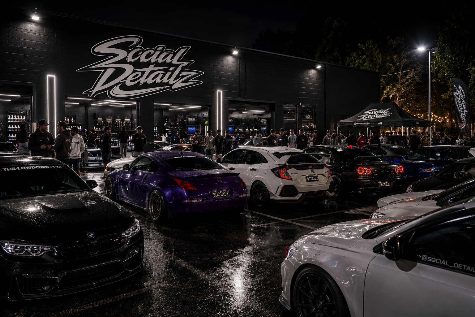 Nighttime car meet outside a black building with people gathered around luxury and sports cars, wet pavement reflecting lights, and a banner reading 'Social Detailz'.