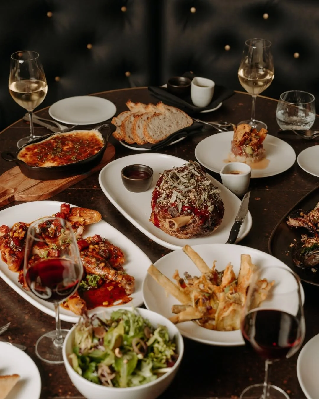 An overhead spread of shared dishes and wine at a Blackbird Melbourne Christmas dinner