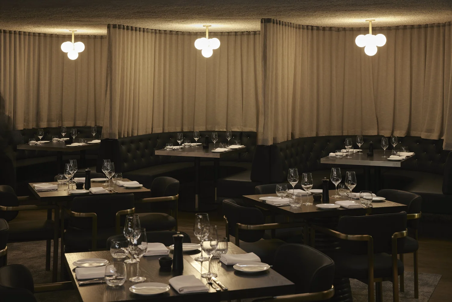 Dining room at Blackbird Melbourne with banquette seating and draped windows