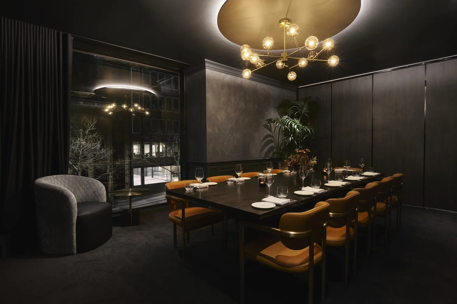 Private Dining Room 3 set for dinner beside the window, with a lounge chair alongside