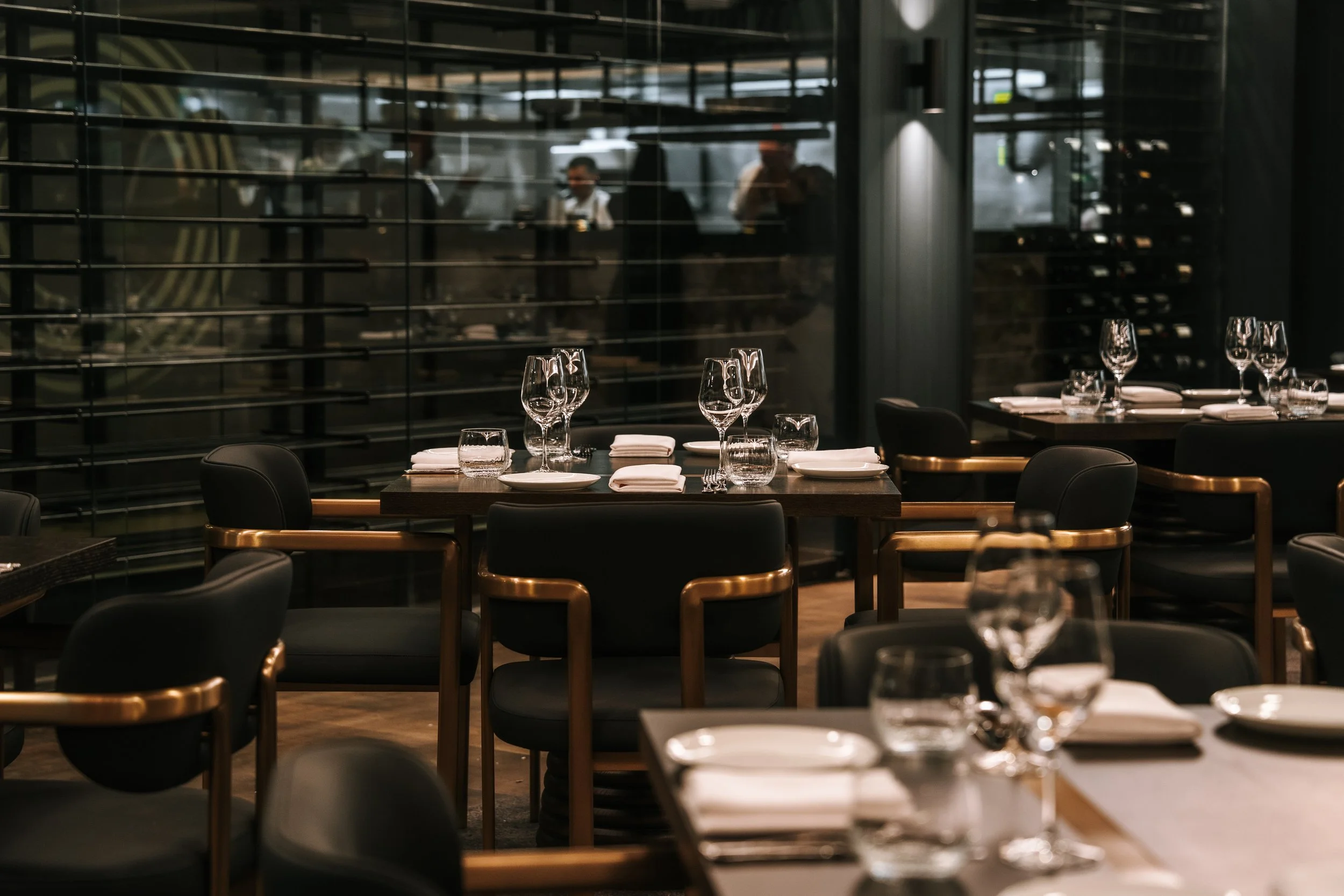 Dining room at Blackbird Melbourne set with glassware beside full-height windows