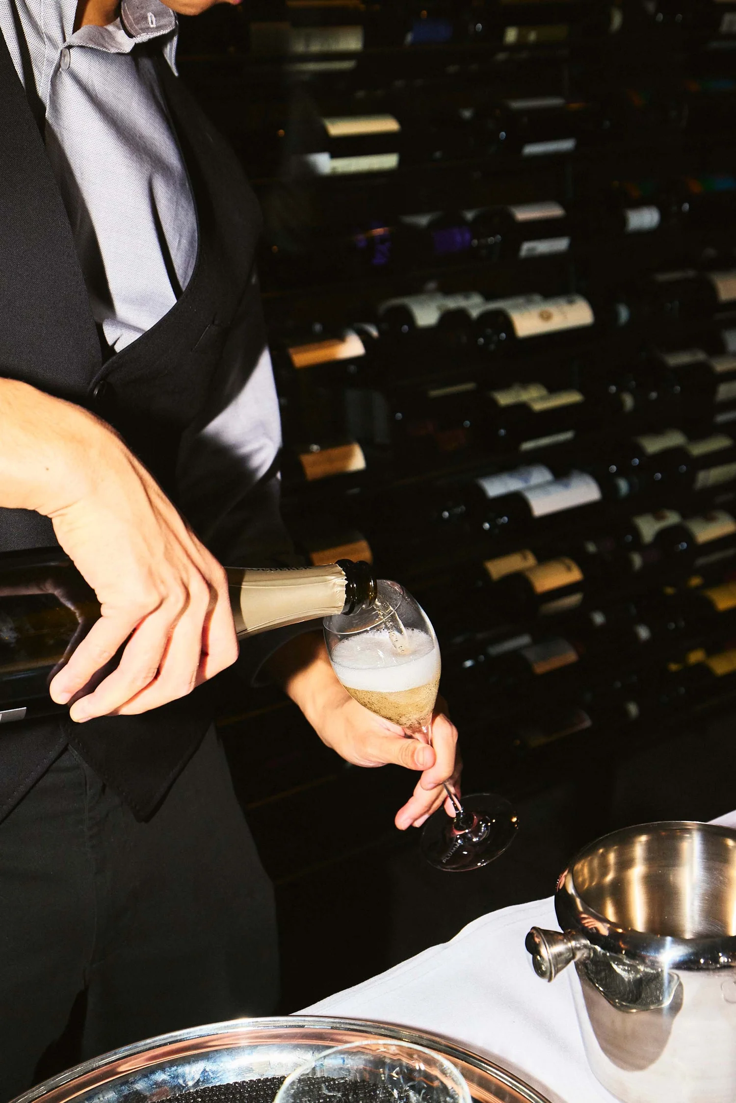 Blackbird Melbourne sommelier pouring wine beside the venue's wine display