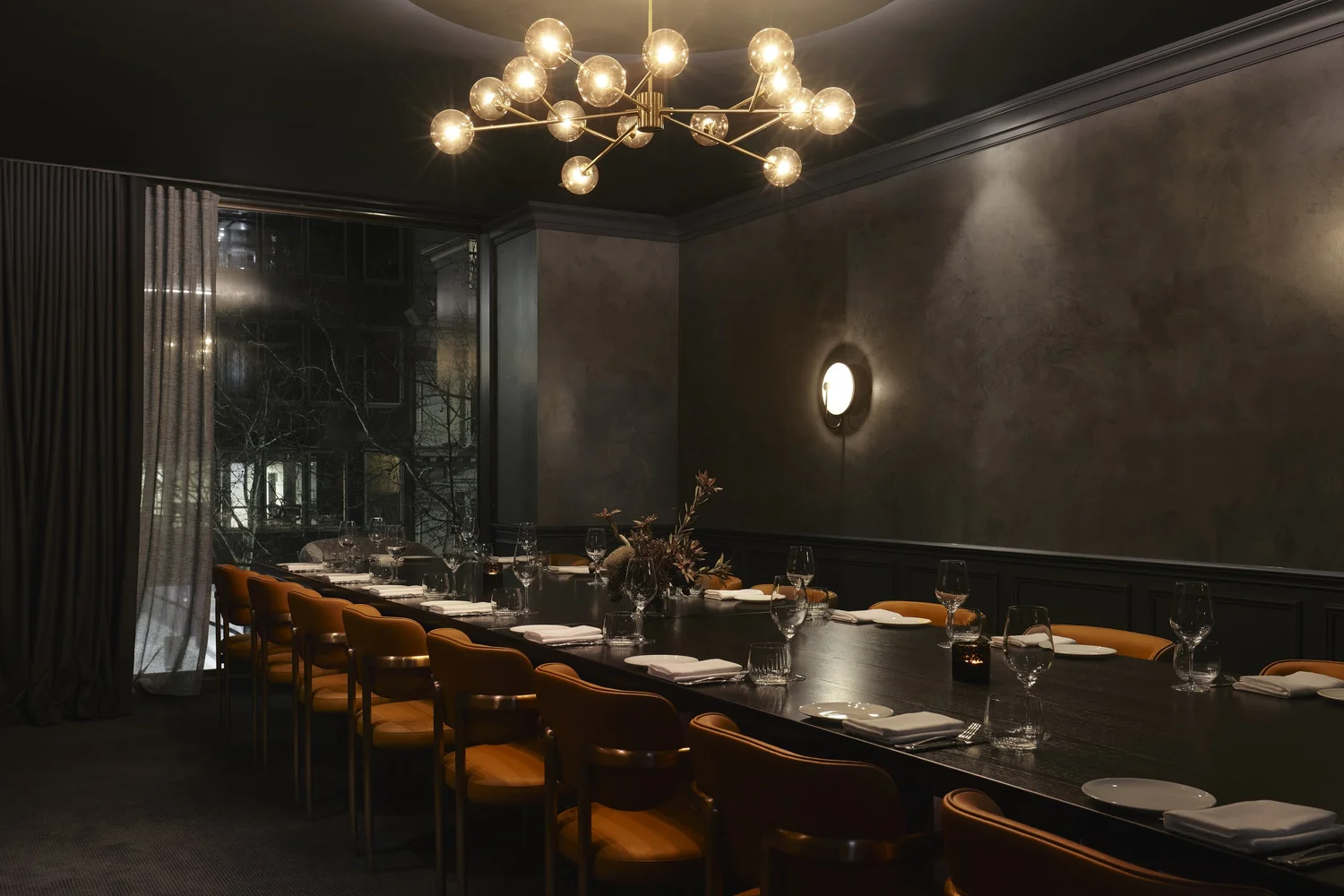 Private Dining Rooms 2 and 3 combined into one long table beneath a brass chandelier