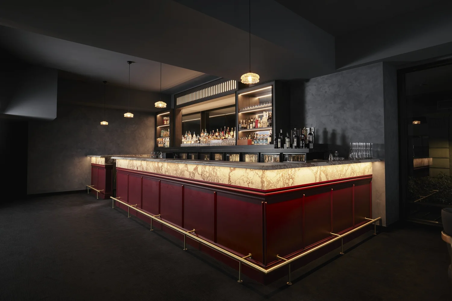 The private top-floor bar with a backlit onyx counter