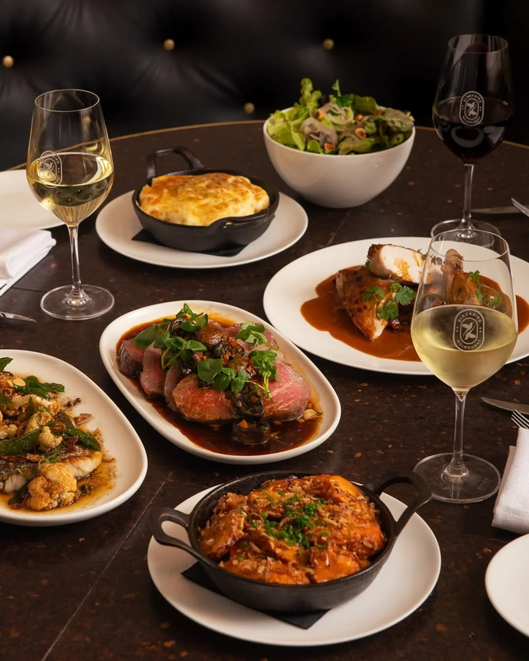 An overhead spread of shared dishes and wine at Blackbird Melbourne