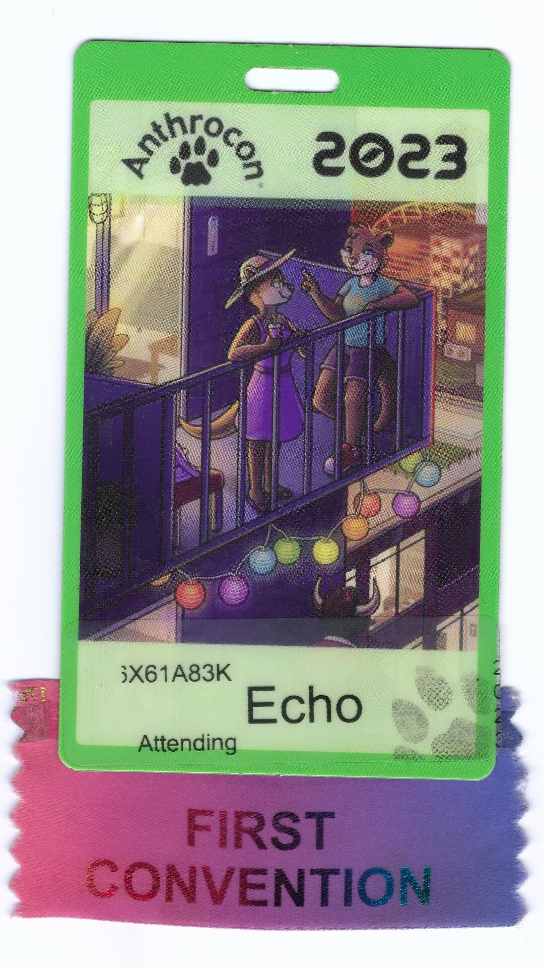 A convention badge with a green border labeled 'Anthrocon 2023' featuring an animated illustration of two anthropomorphic cats on a balcony, with colorful string lights hanging below.