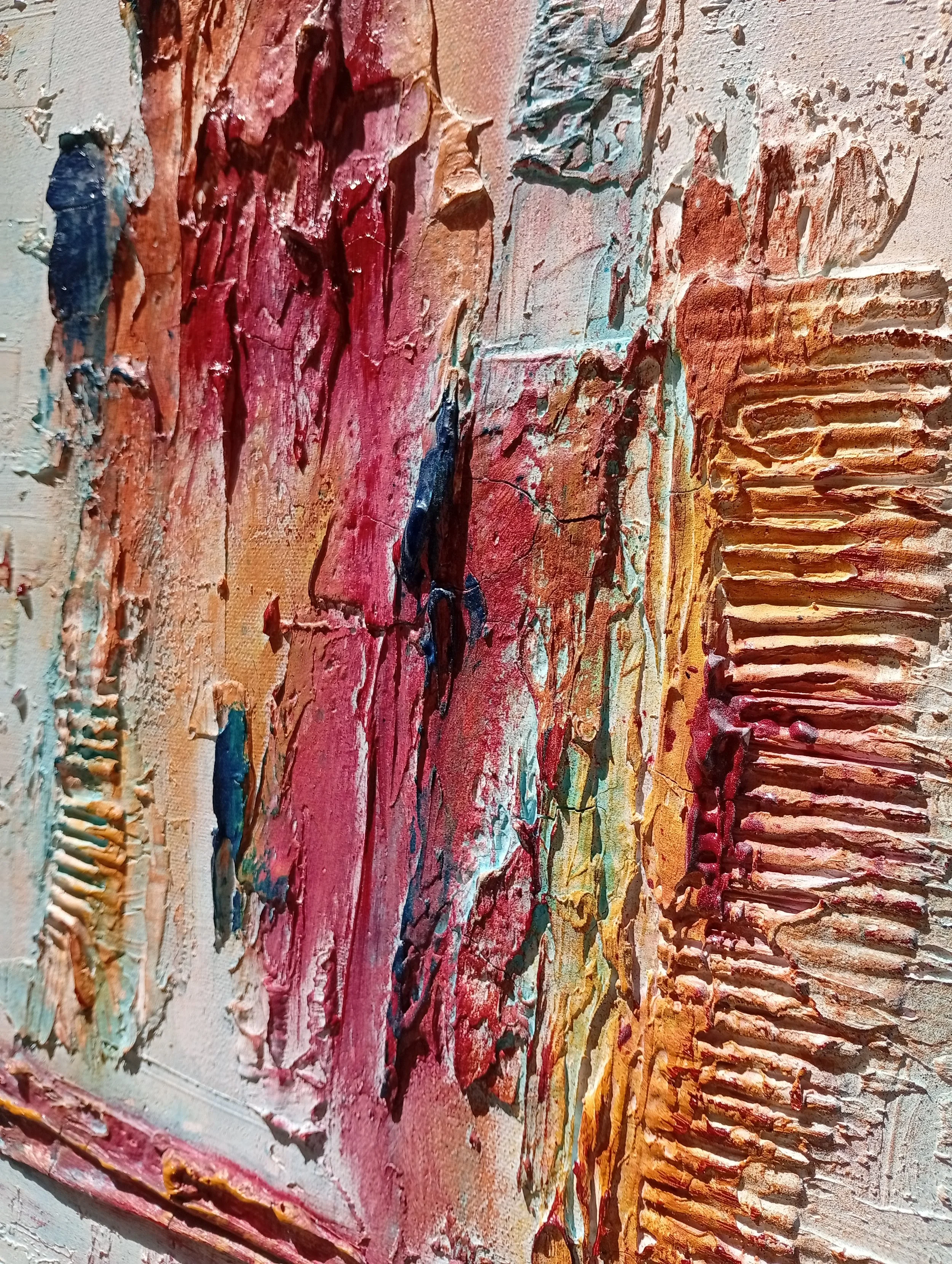 Dettaglio di un dipinto astratto con colori caldi come rosso, arancione, rosa e tocchi di blu, applicati con spatola creando texture in rilievo.