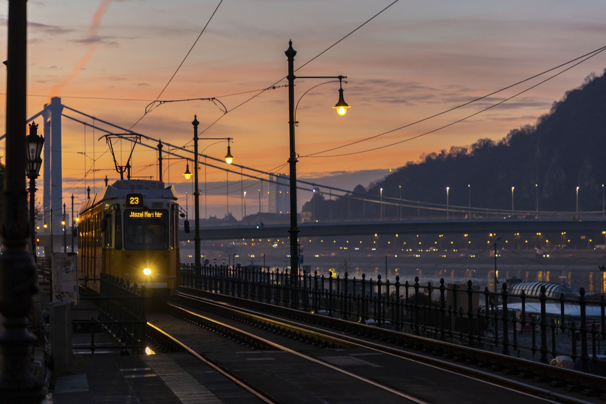 A tram drives towards the camera at sunrise in Budapest, Hungary.