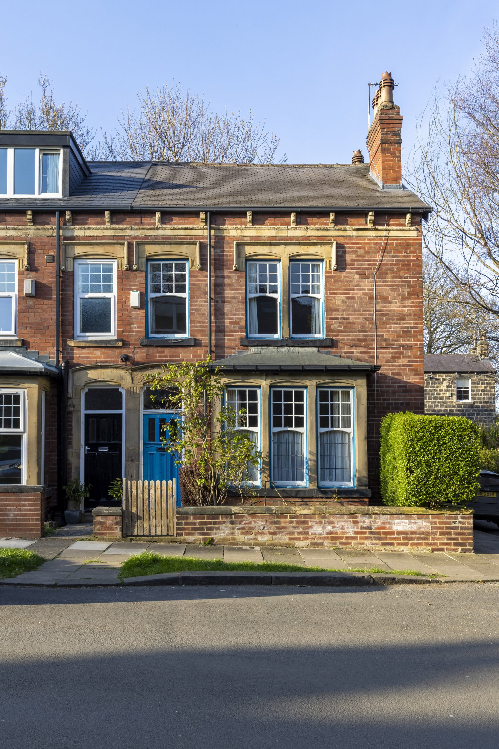 A row of terraced houses in a residential area photographed straight-on for a professional property photograph on a bright sunny day.