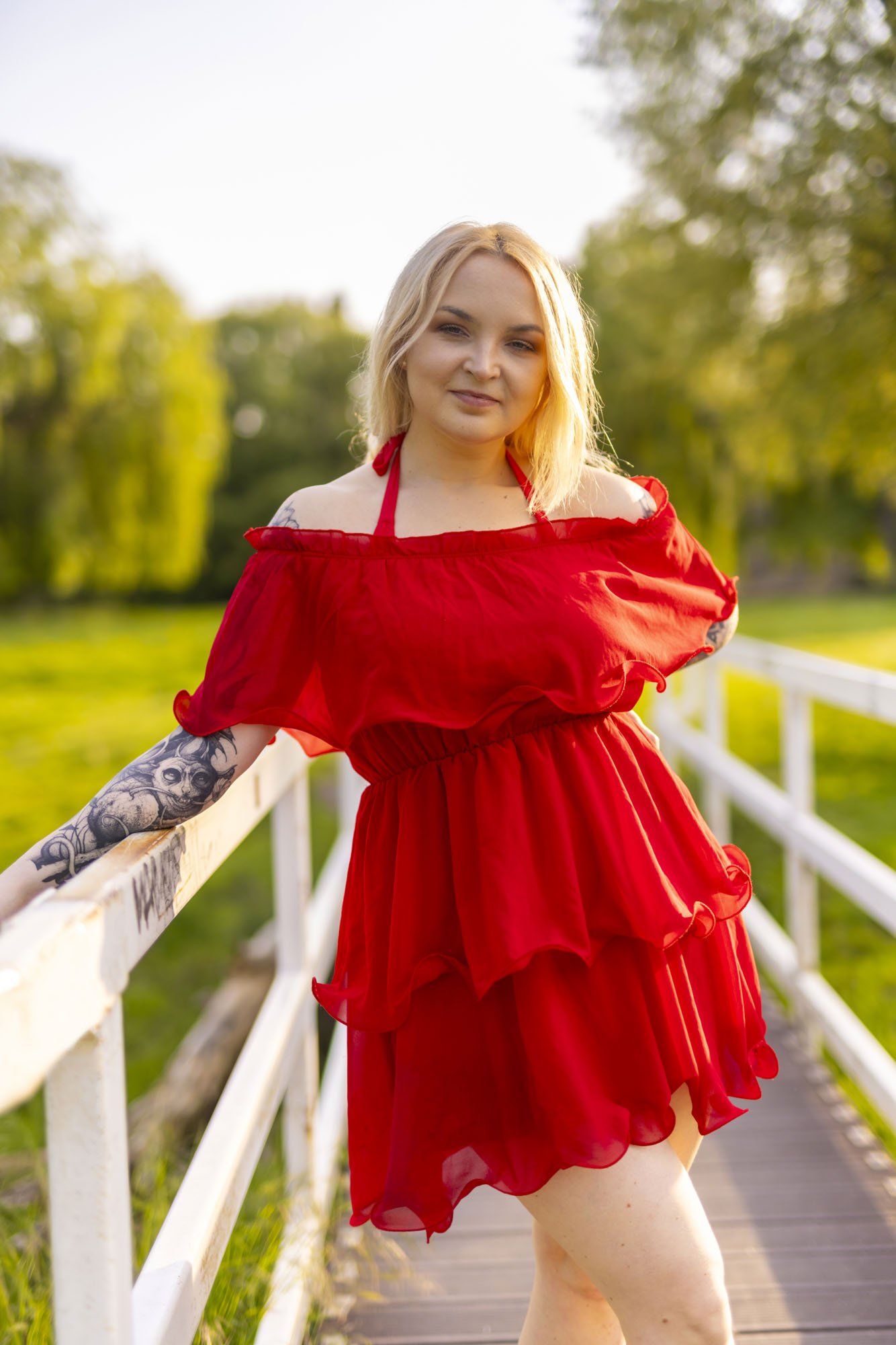 Model Rose Ford poses for some portraits on a bridge in Cambridge wearing a vibrant red dress.