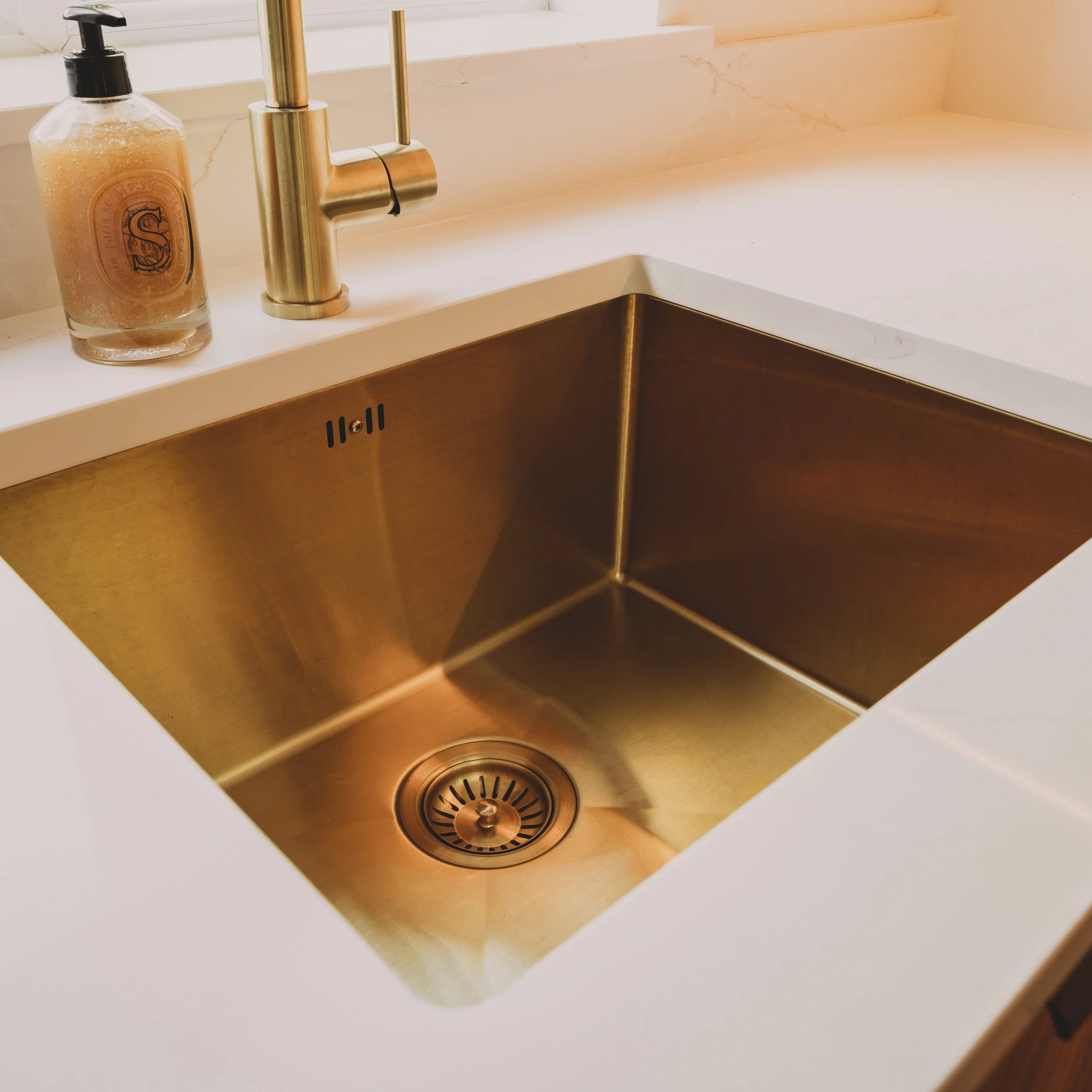 A touch of something unique, a brushed brass sink bringing warmth, character and elegance to this Scandinavian kitchen designed by Lou Joia Studio. #interiordesign #brass #danish #japandi