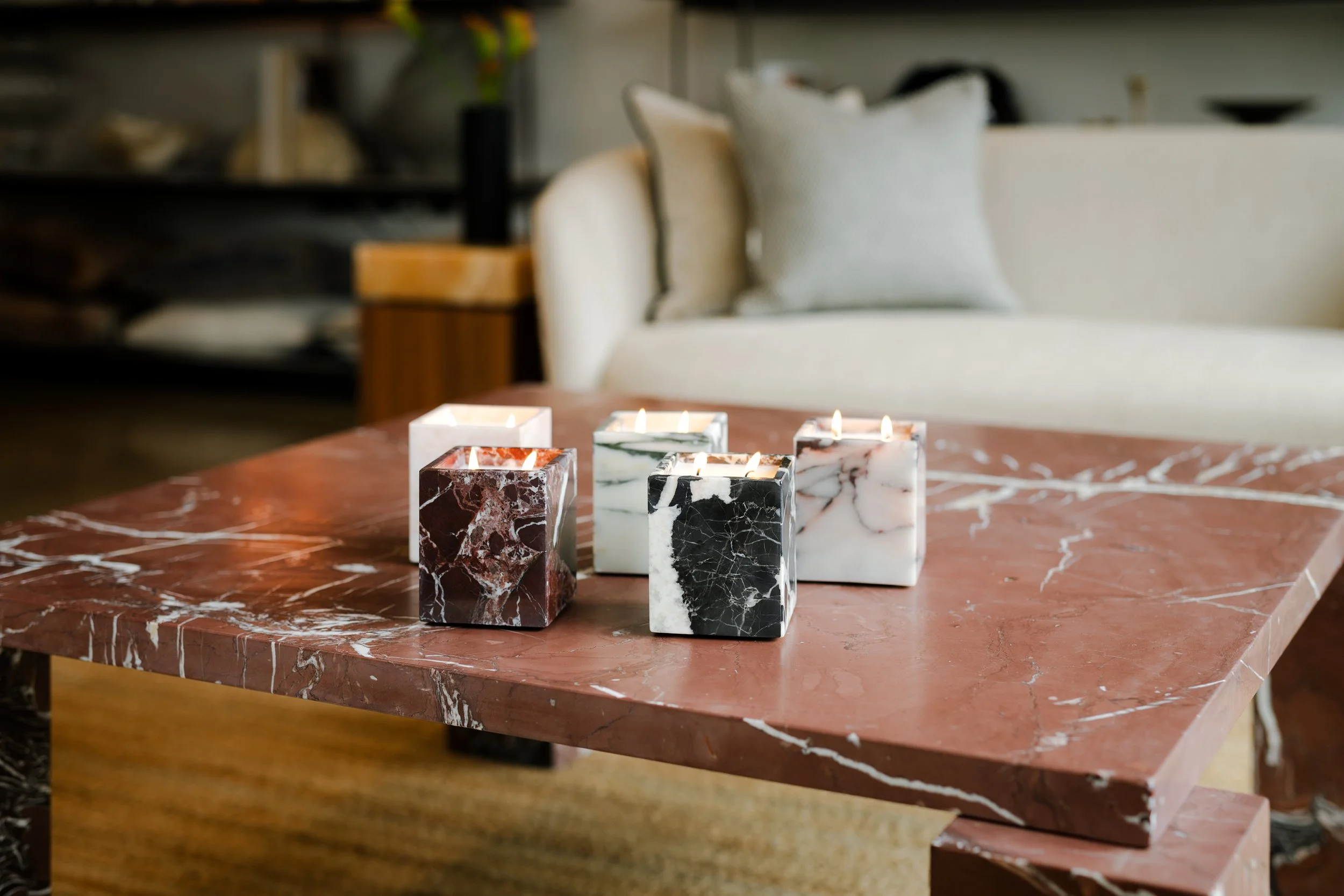 Marble candles on a red marble table.