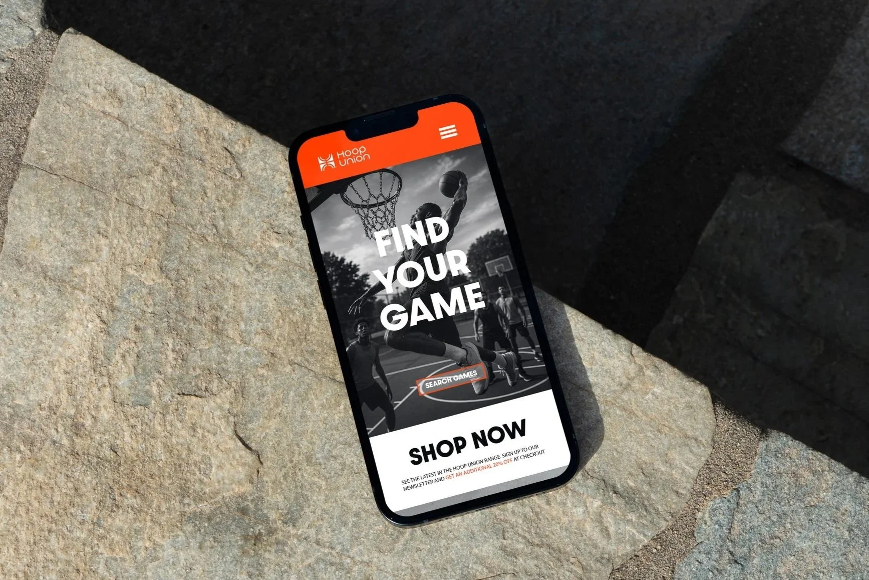 Mobile phone displaying a sports-themed app called Hoop Union with a basketball player dunking, and text that says "Find Your Game" and "Shop Now".