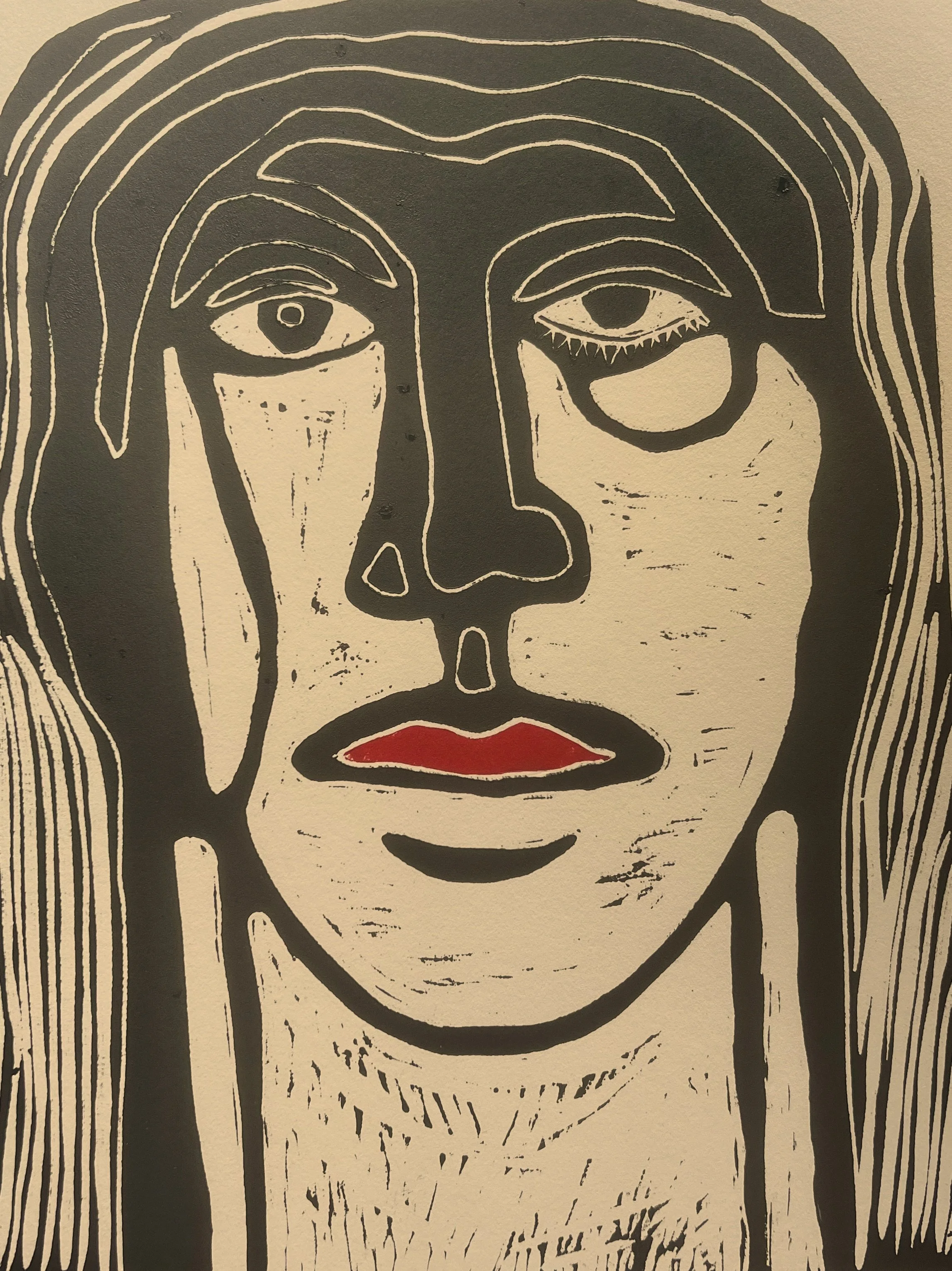 A black and white abstract portrait of a person's face with asymmetrical features, red lips, and long hair, drawn with bold lines and a sketch-like style.