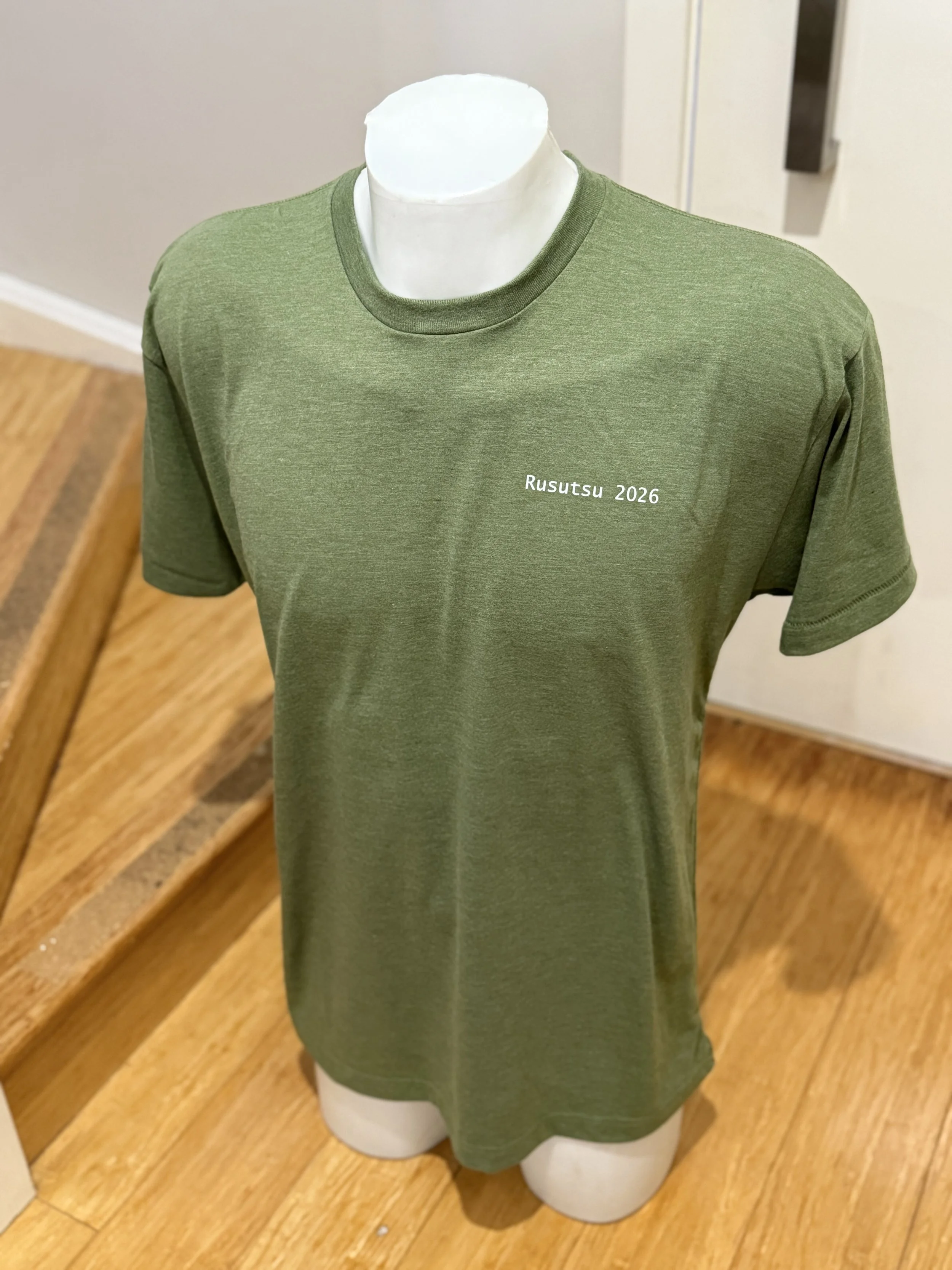 Green T-shirt on a mannequin with text 'Rusutsu 2026' printed on the chest.