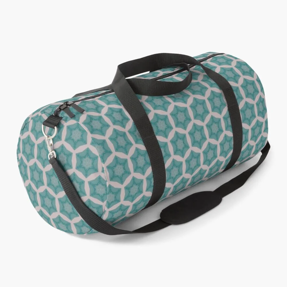 A teal and white patterned duffle bag with black straps and a shoulder pad.