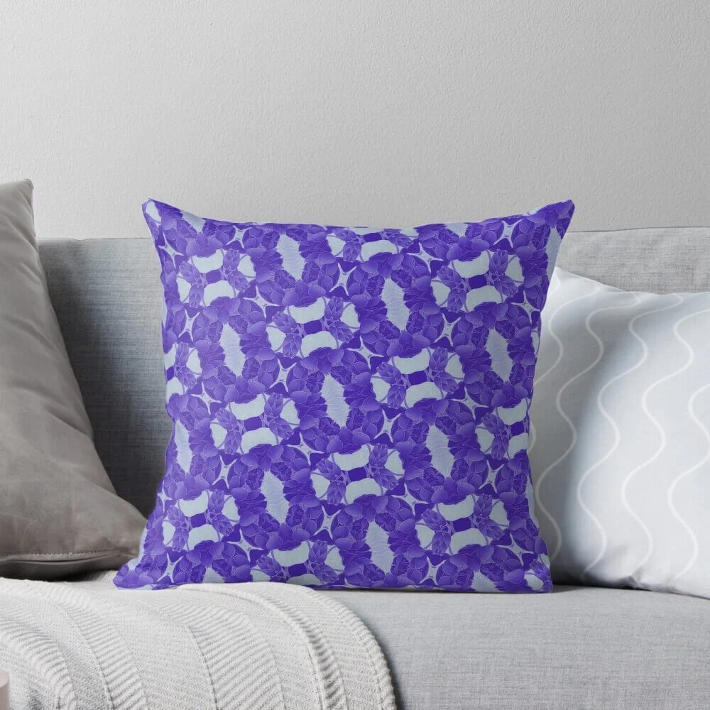 Decorative pillow with purple floral pattern on a gray sofa.