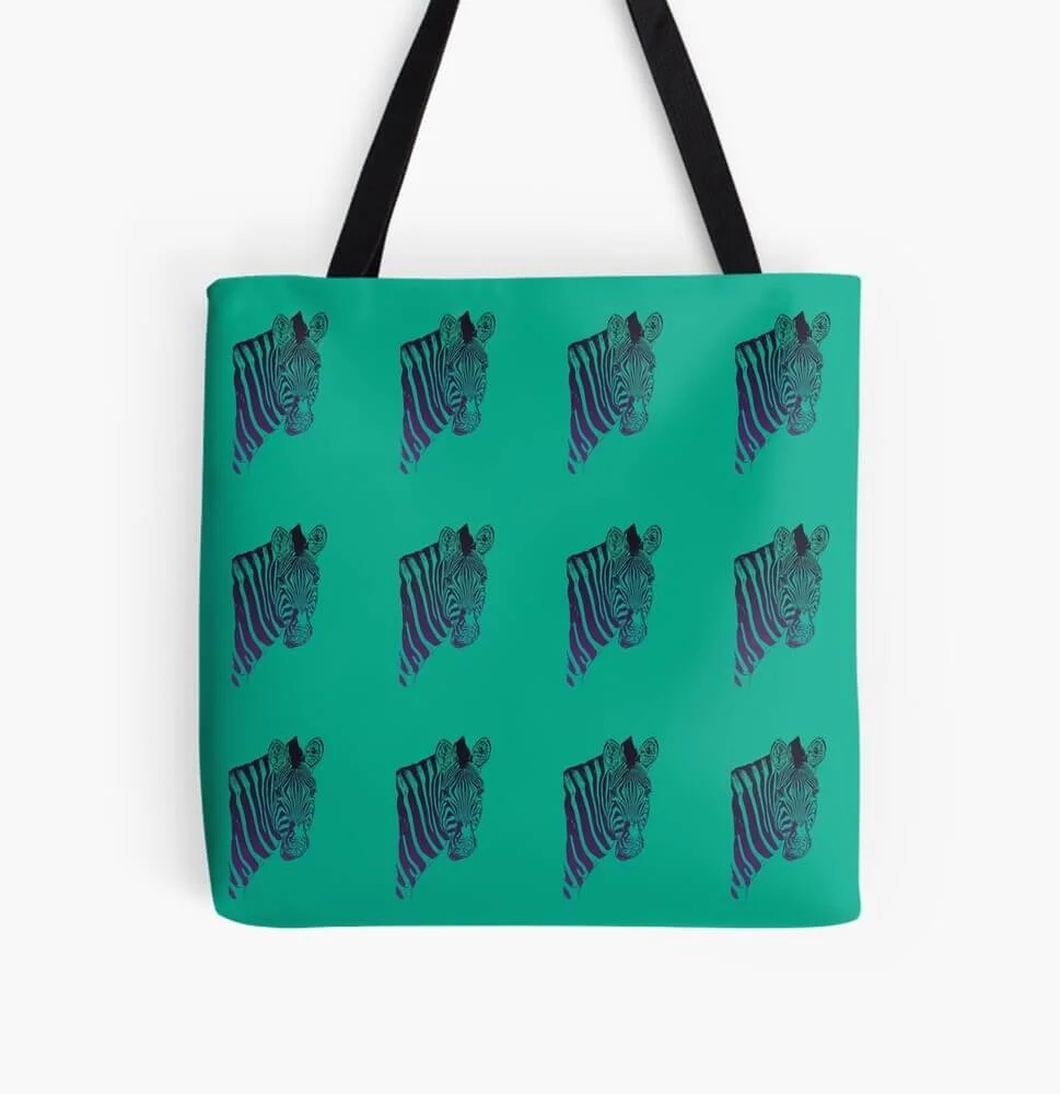 Green tote bag with repeating blue and black zebra head pattern, hanging from black handles against a white background.
