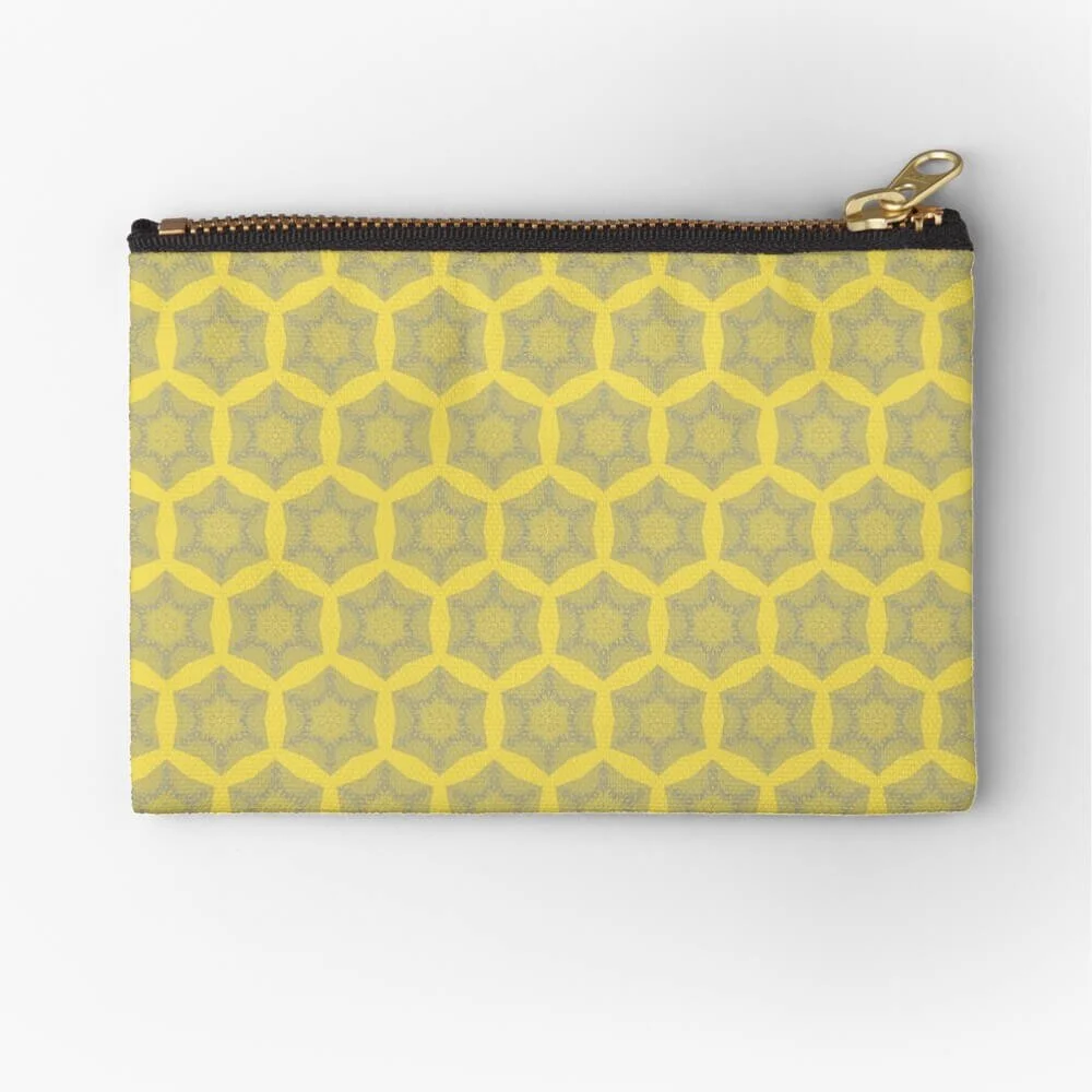 Yellow fabric zippered bag with a geometric pattern of interlocking shapes and a gold zipper pull in the top right corner.