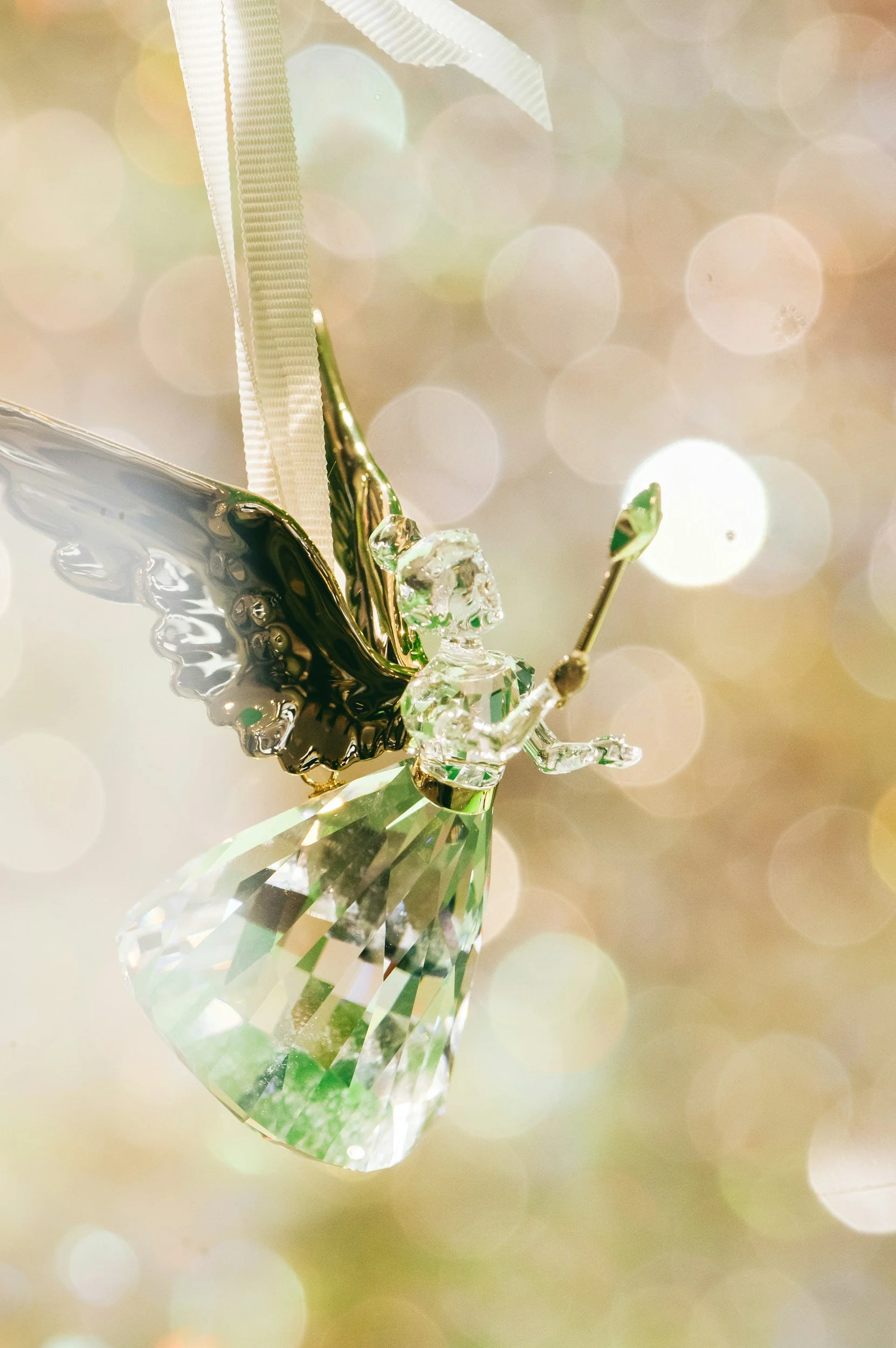 A beautiful guardian angel crystal ornament captured mid-flight with a wand, symbolising the personal protection and guidance of our guardian angels.