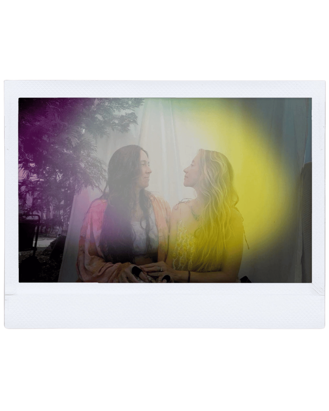 Two women sitting close together, facing each other indoors, with sunlight shining behind them, and a purple and yellow overlay effect.