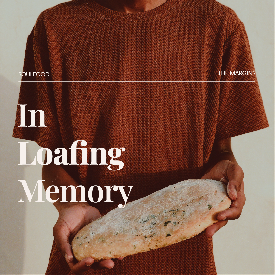 A person wearing an orange textured shirt holding a large loaf of bread.