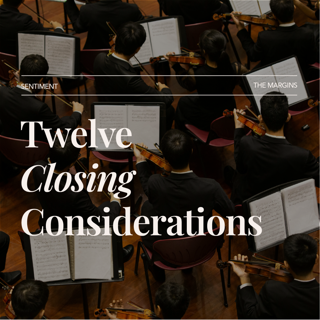 An orchestra of musicians playing string instruments such as violins, viewed from above, with sheet music on stands in front of them.